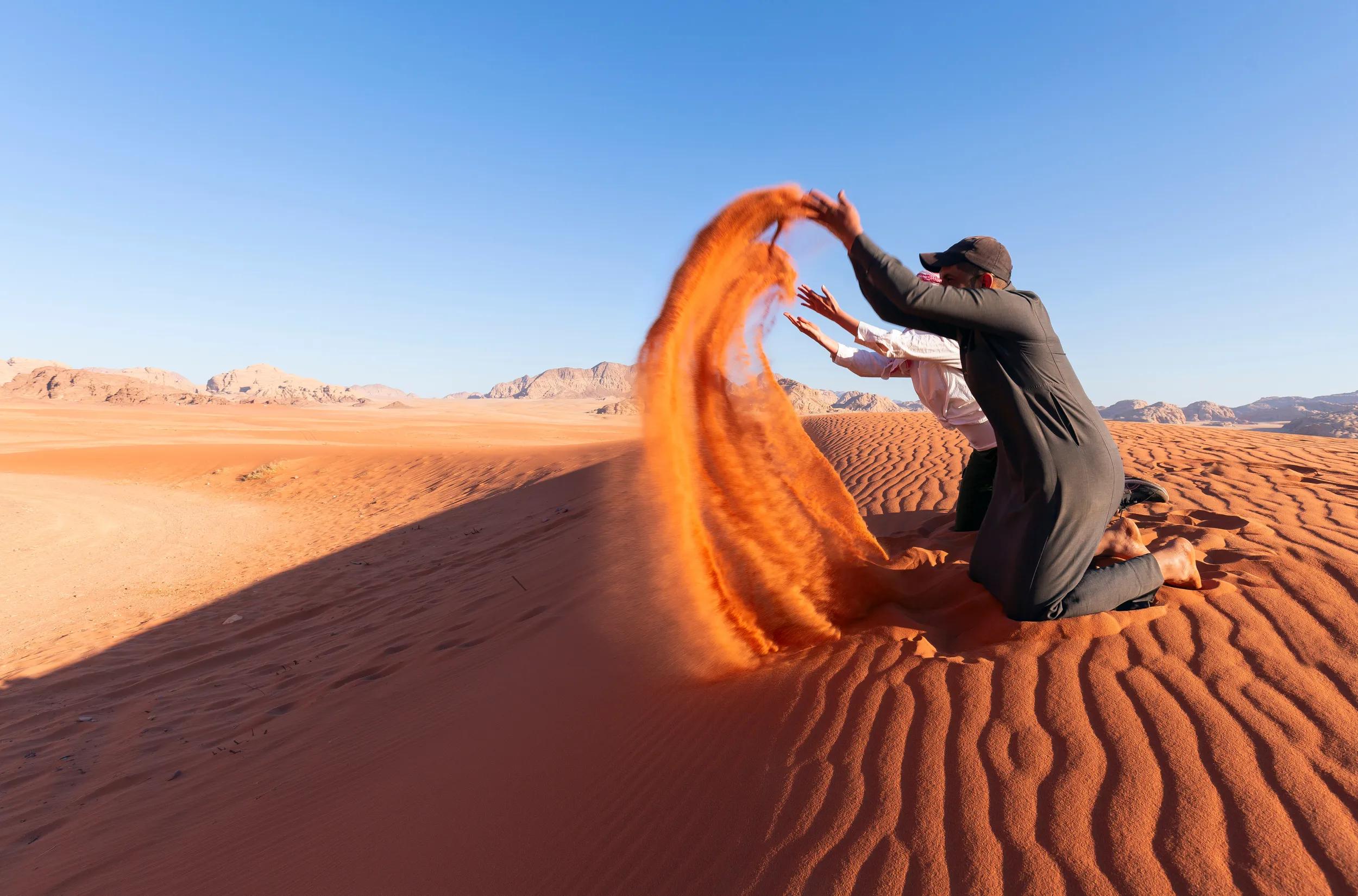 Tourist playing sand in Wadi Rum Desert, Jordan