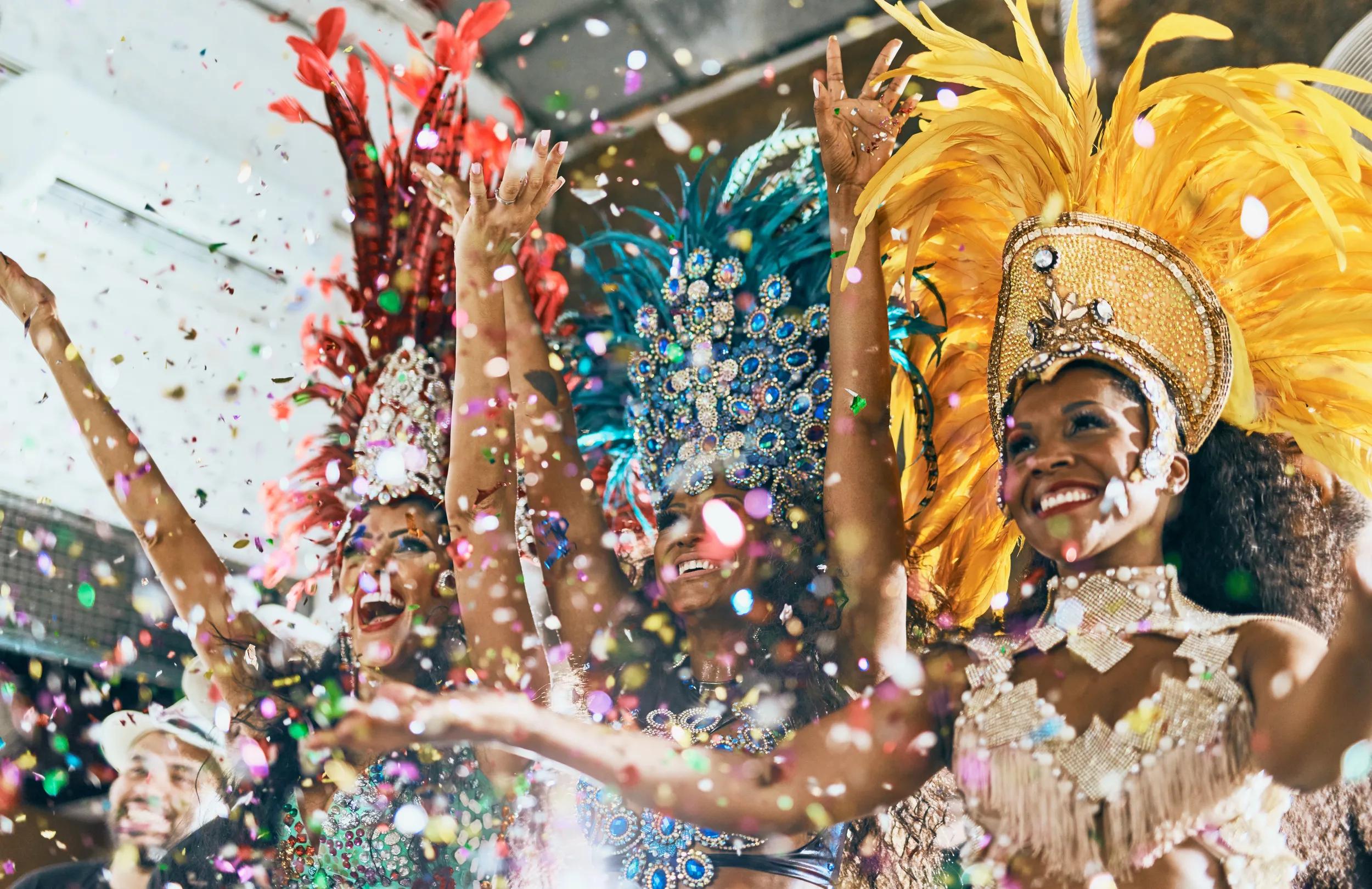 Cropped shot of beautiful samba dancers performing in a carnival with their band.