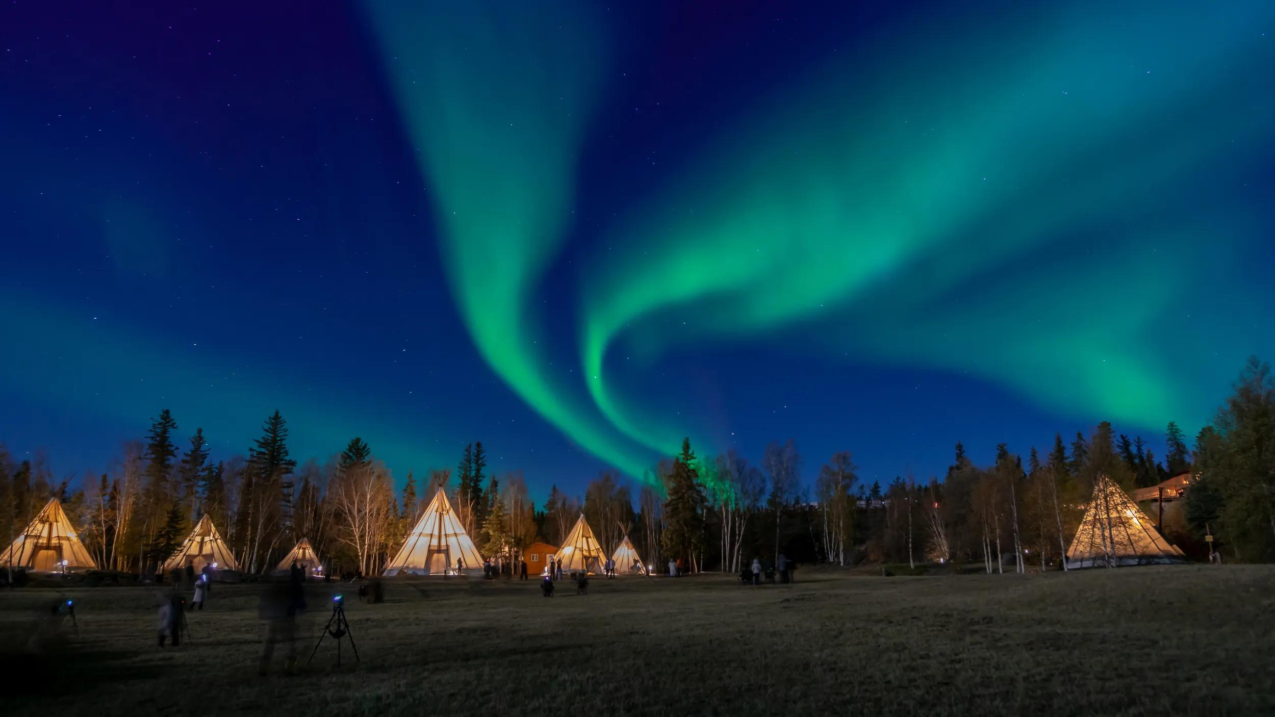 Many lightup Tipi with Aurora Borealis at Yellow Knife, Canada