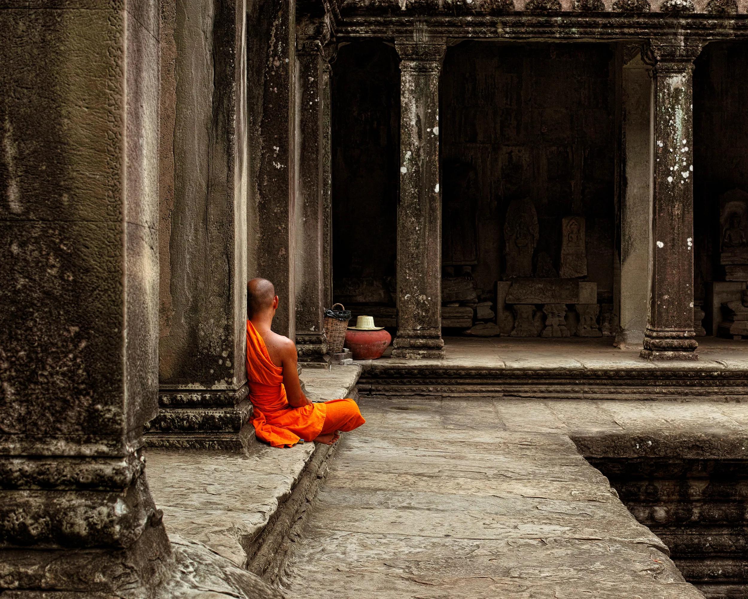 A monk meditates at the Angkor Wat temple in Siem Reap Cambodia.