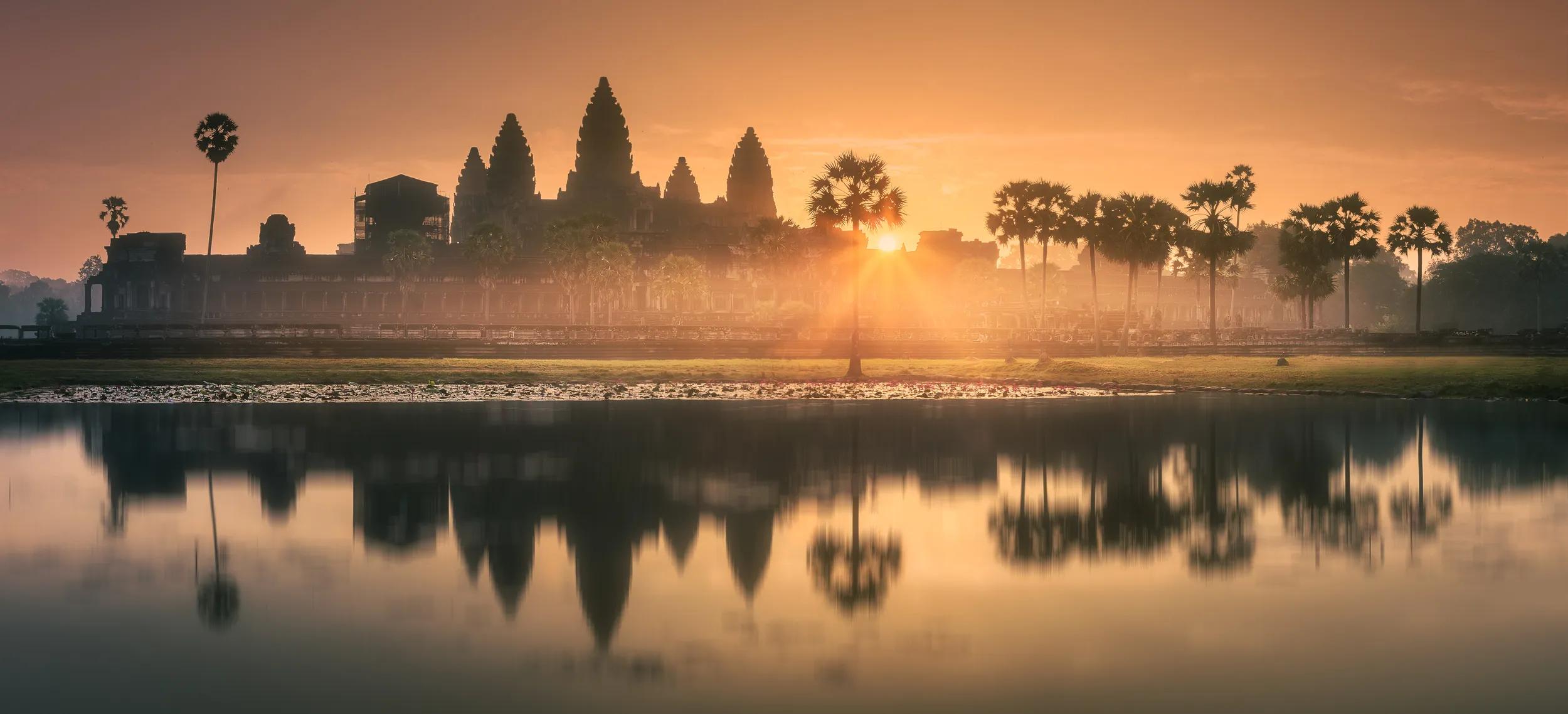 Sunrise view of popular tourist attraction ancient temple complex Angkor Wat with reflected in lake Siem Reap, Cambodia. Clipping path of sky