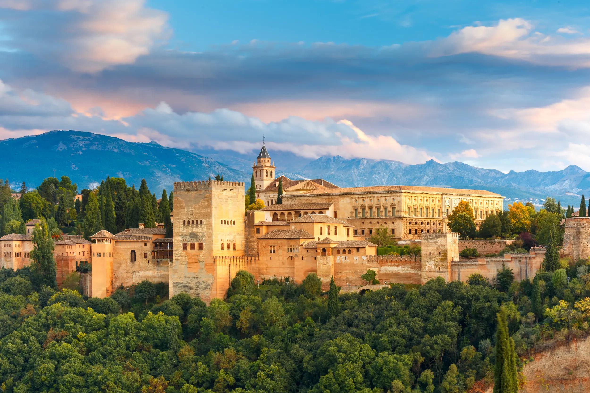 Palace and fortress complex Alhambra with Comares Tower, Palacios Nazaries and Palace of Charles V during sunset in Granada, Andalusia, Spain