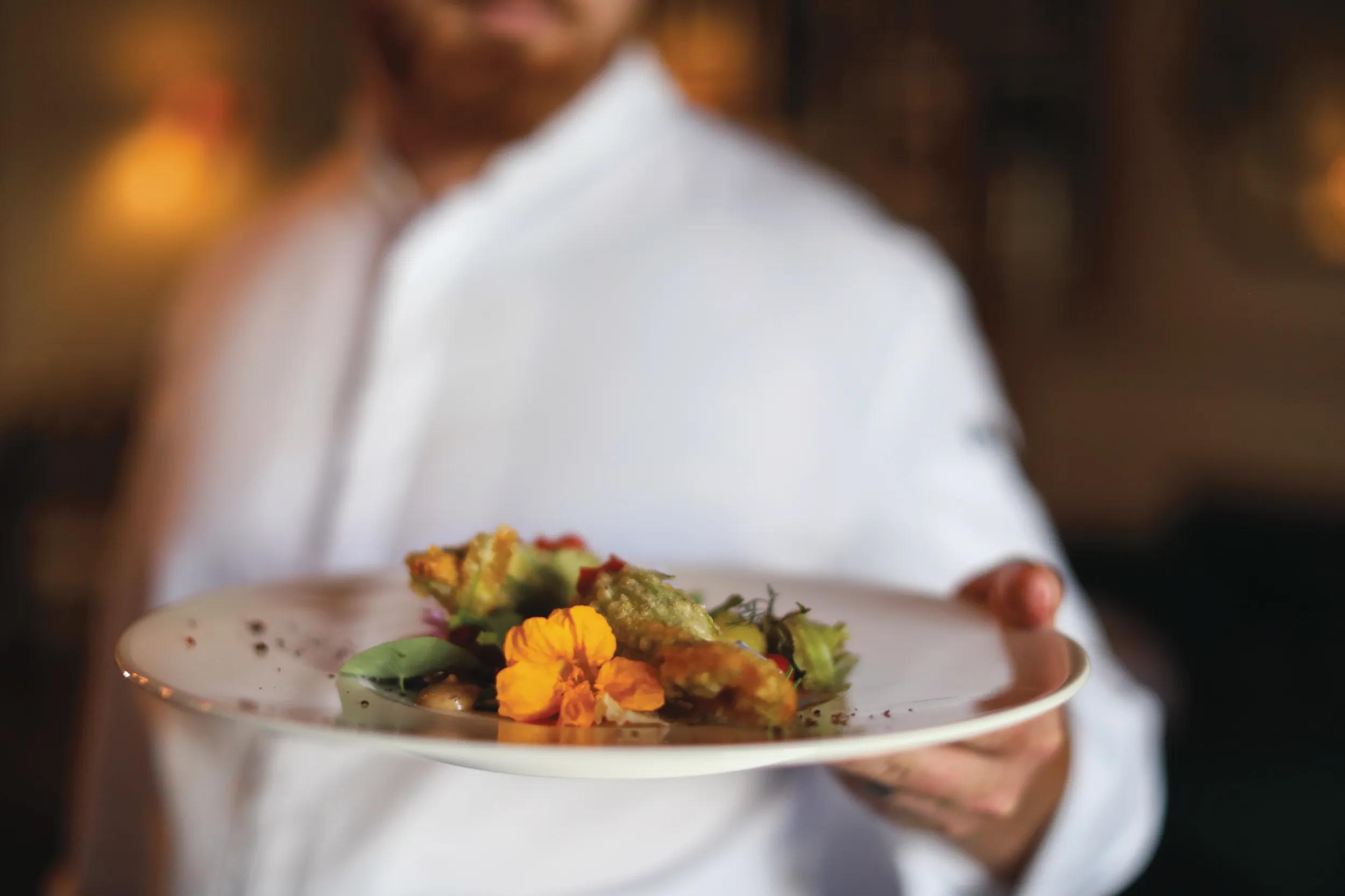 The head chef at a gourmet restaurant preparing for dinner service, in Somerset West, South Africa.