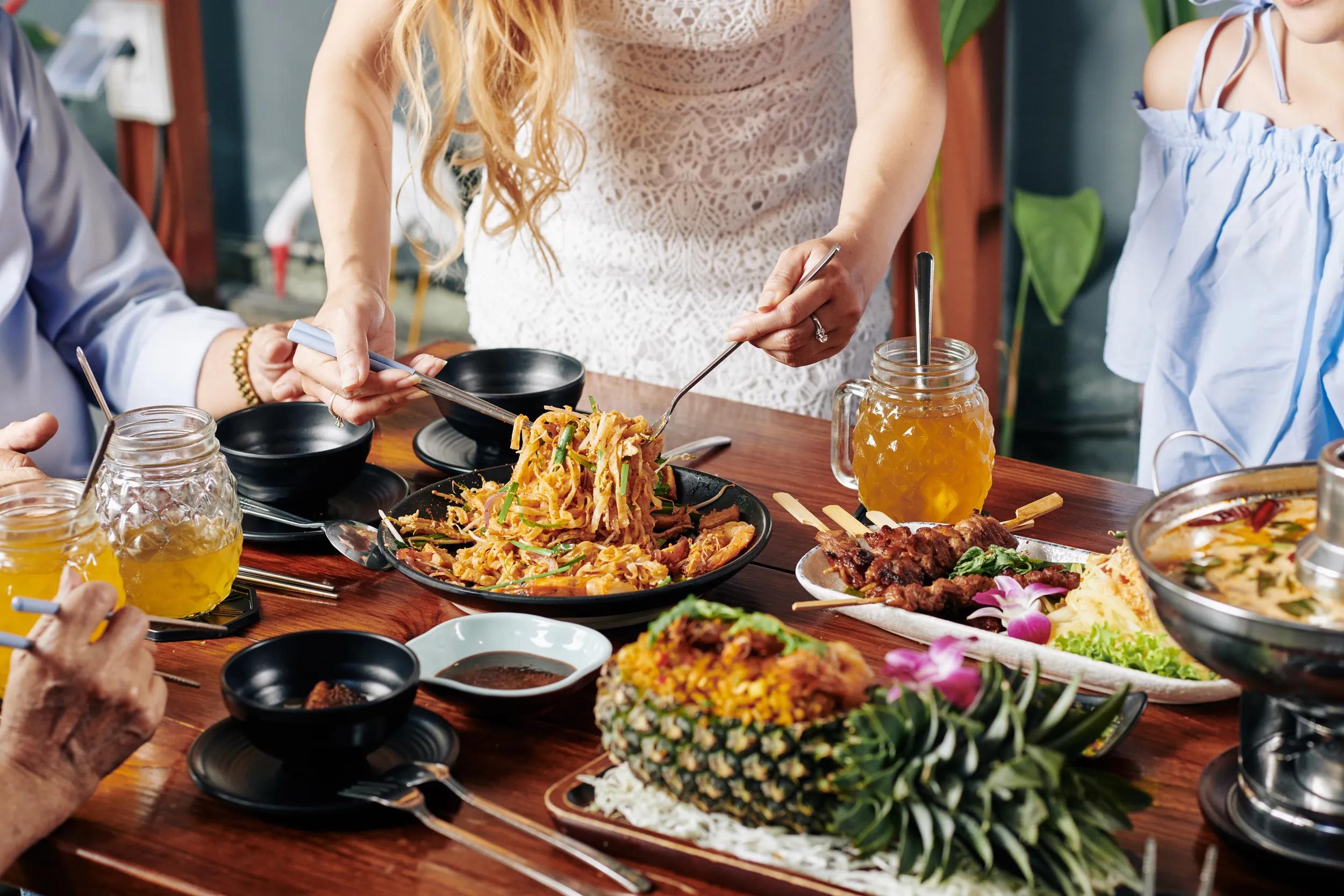 Woman serving food at dining table.