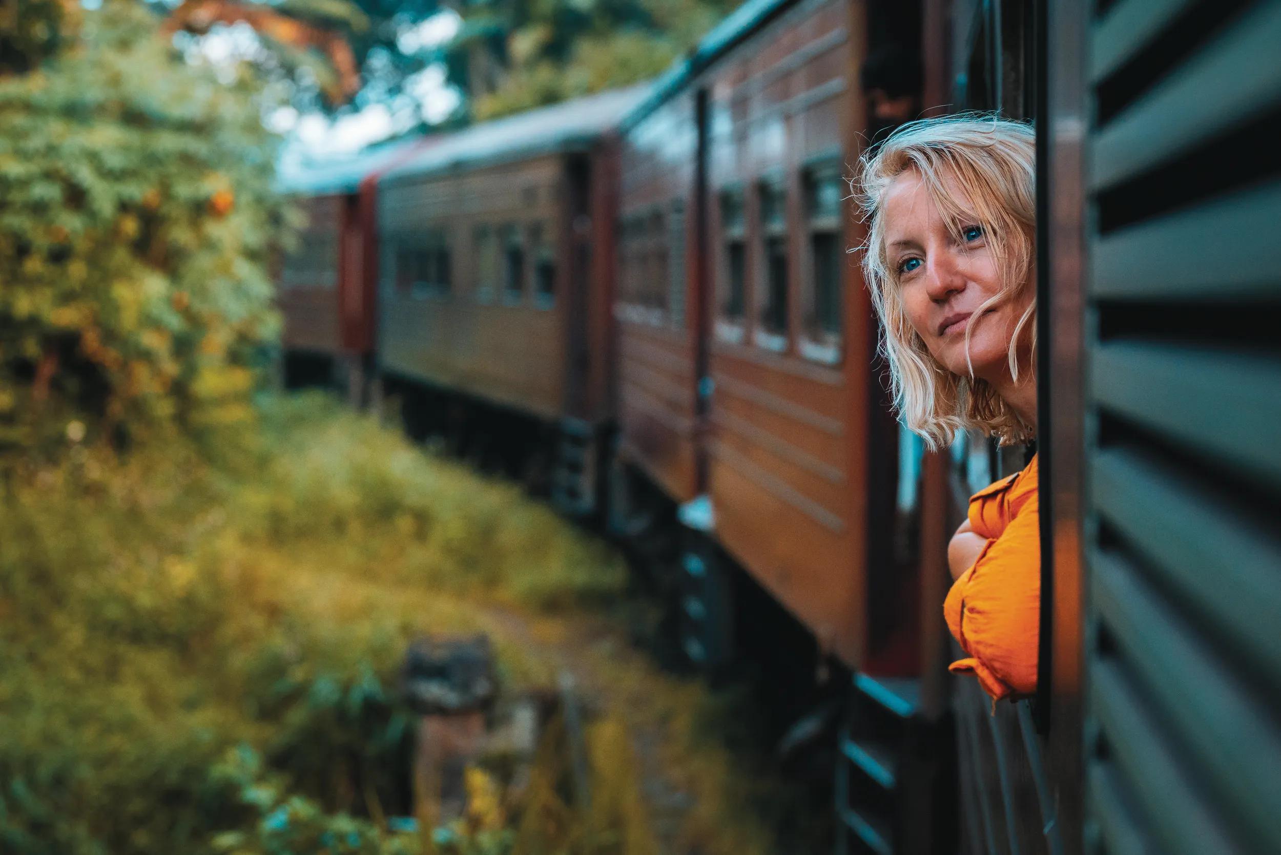 A woman enjoys a train ride in Sri Lanka