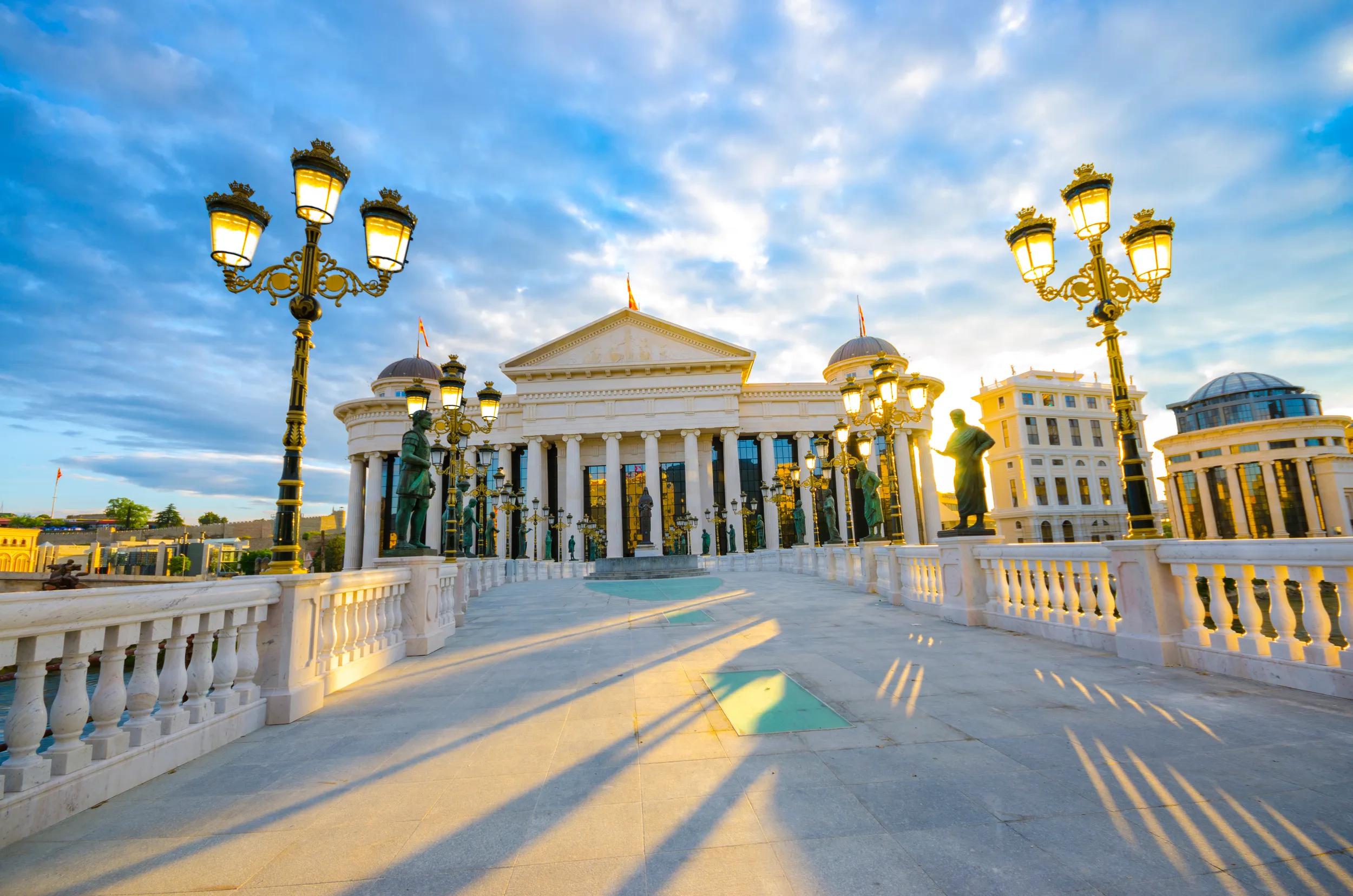 Light posts on the bridge over Vardar river and dramatic shadows from the sunrise sun rays, Bright blue sky, wide angle