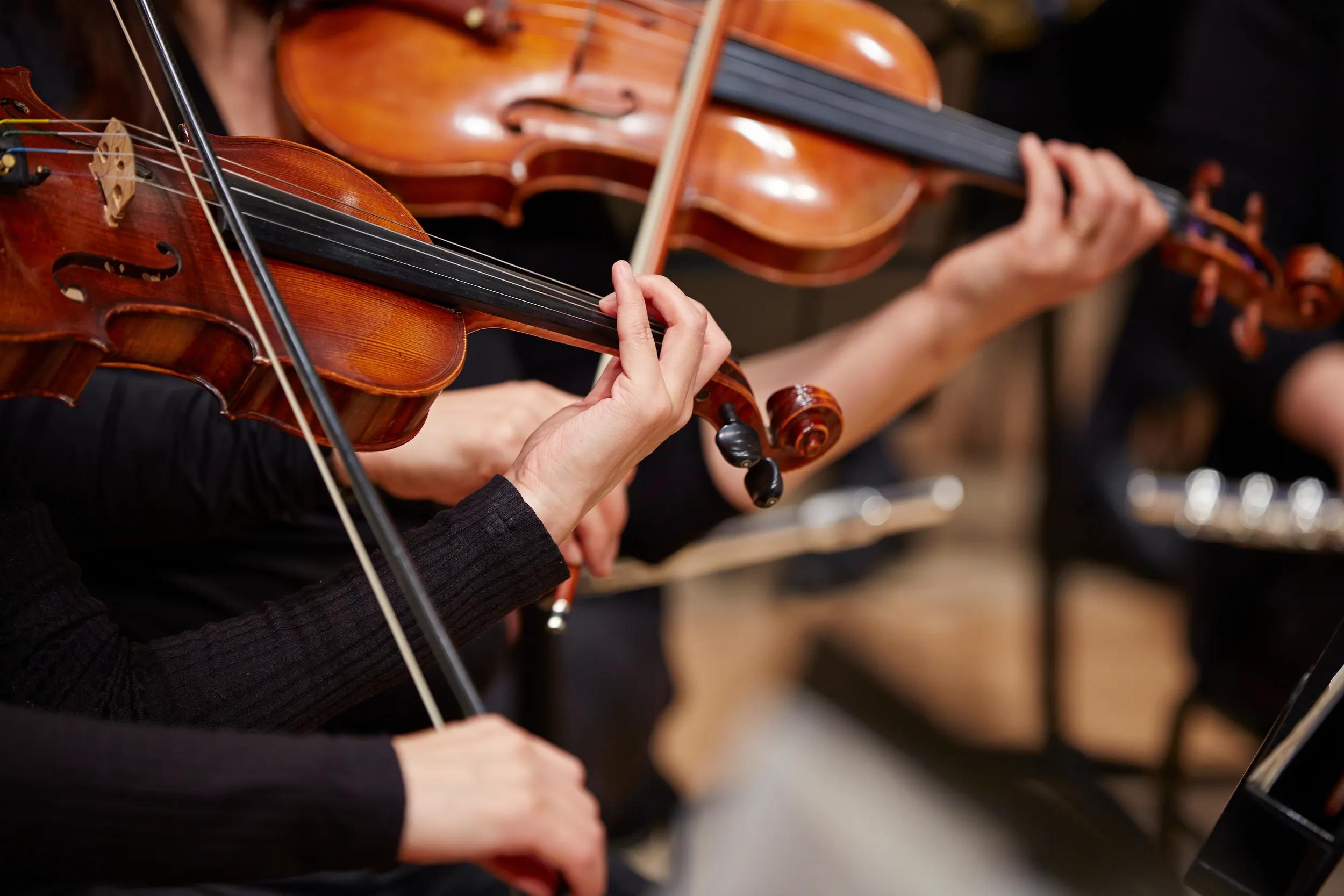 Close-up of musician's hands playing violin.