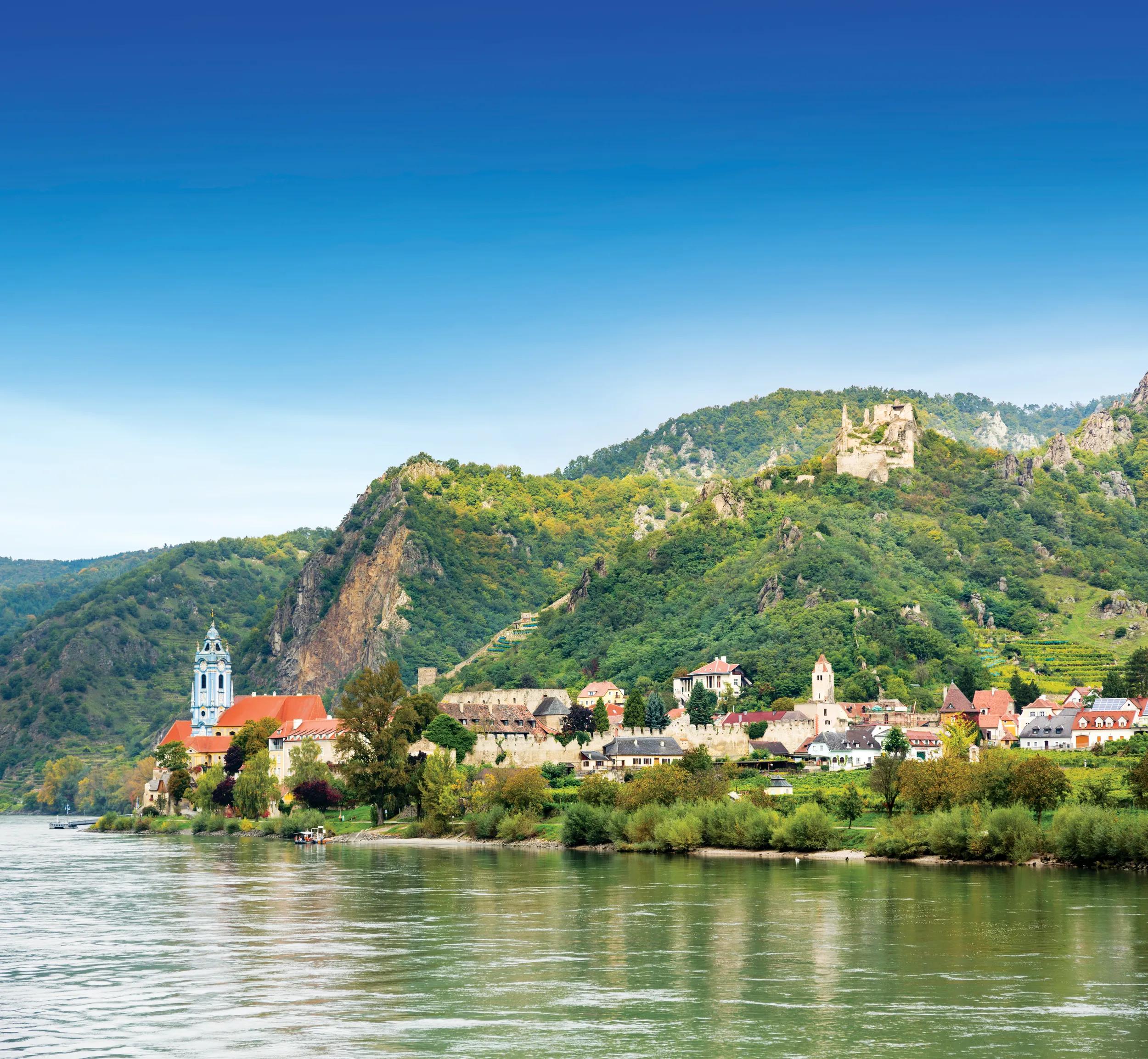 Ornate church and buildings on banks of River Danube in Durnstein, Austria