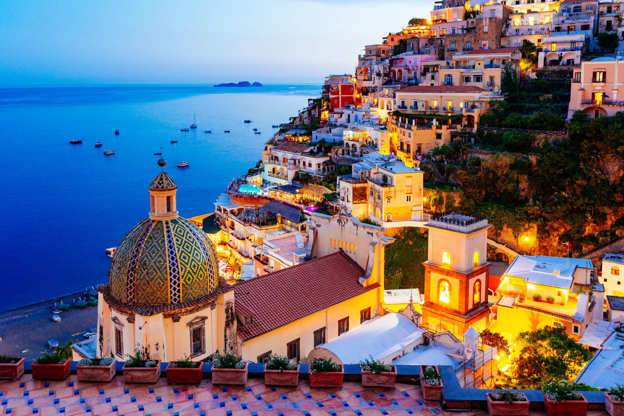 Positano, Amalfi Coast, Campania, Sorrento, Italy. View of the town and the seaside in a summer sunset