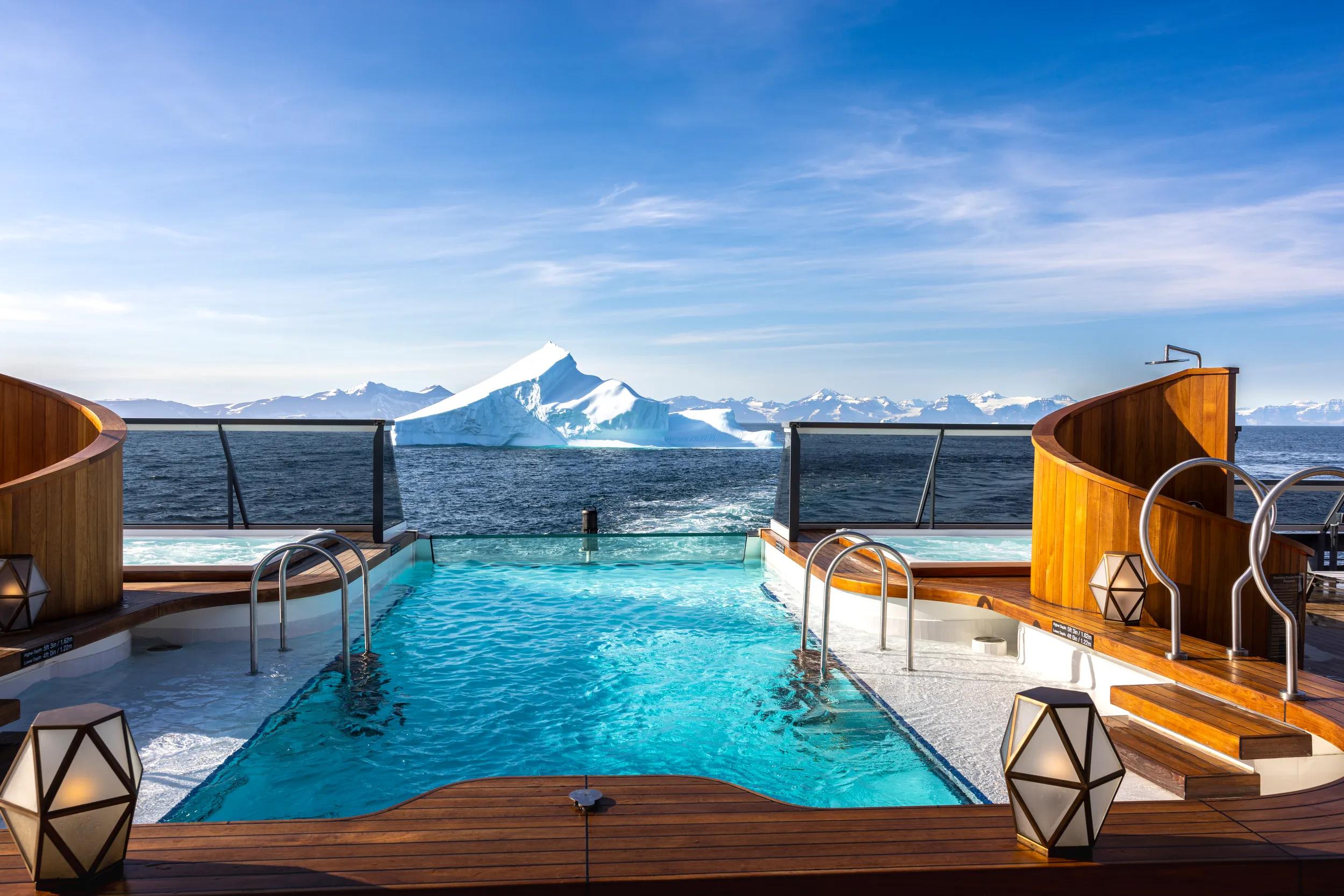 Seabourn Venture, aft section of the ship with pool overlooking iceberg in waters off Greenland.
