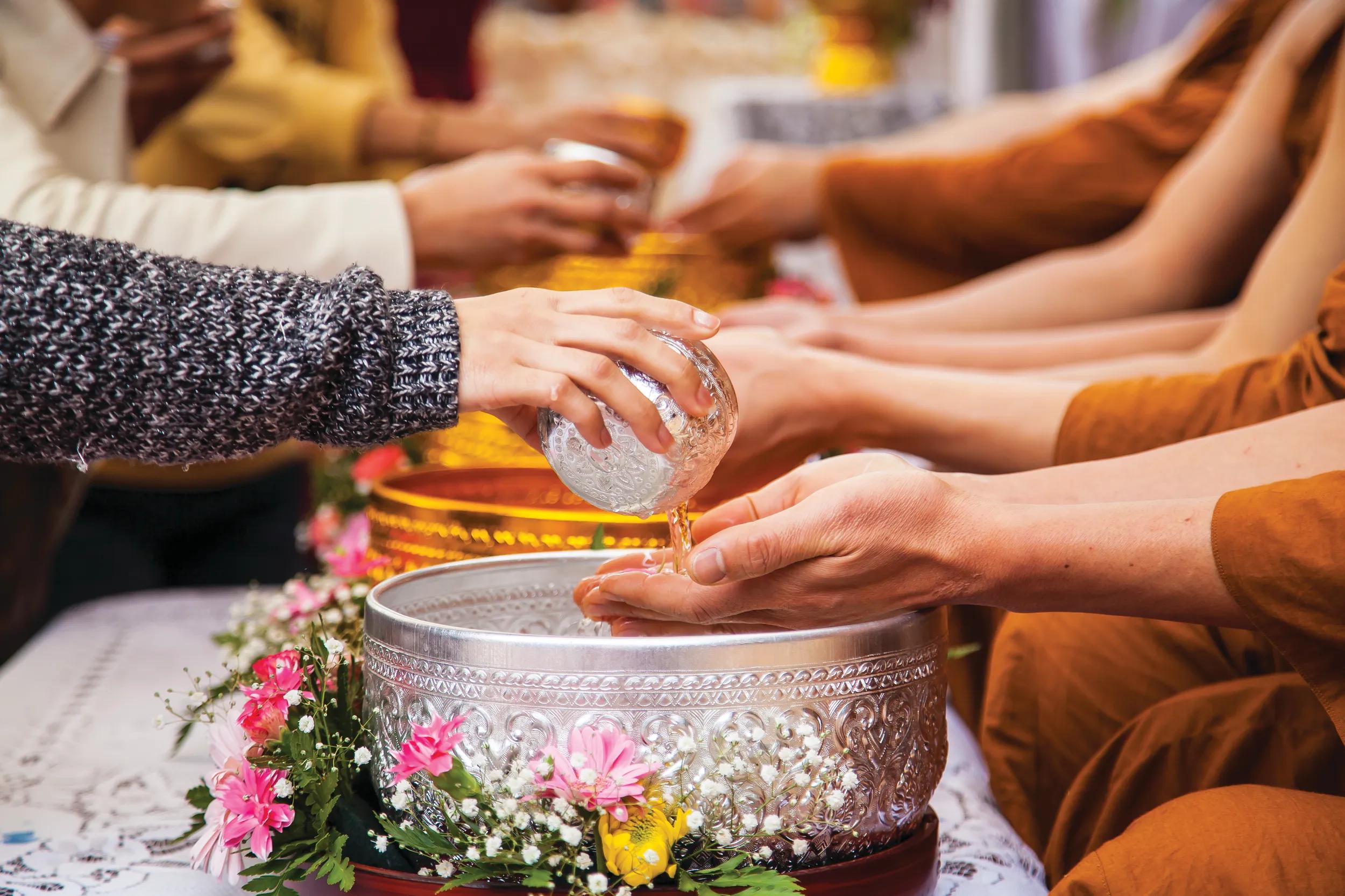 Receiving water by hand, Buddhist blessing, Cambodia.