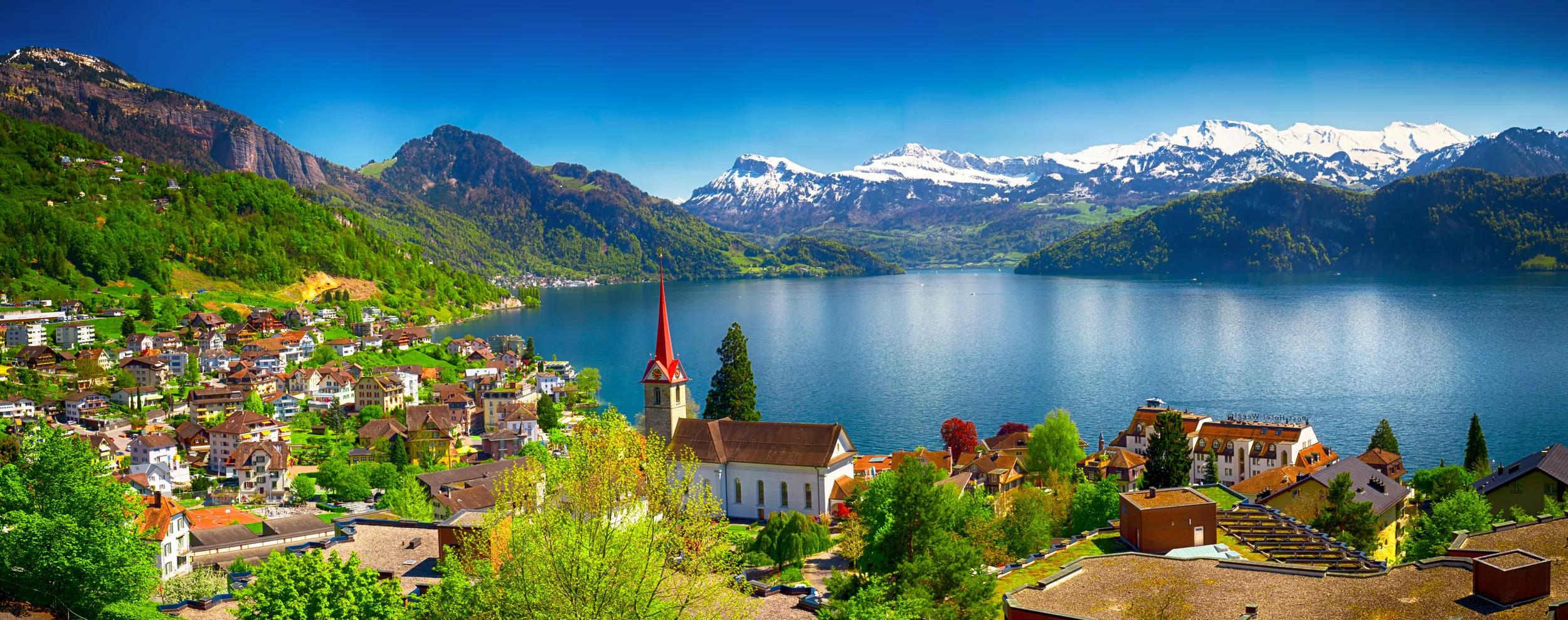 Panorama image of village Wegis, lake Lucerne (Vierwaldstatersee), Pilatus mountain and Swiss Alps in the background near famous Lucerne city, Switzerland