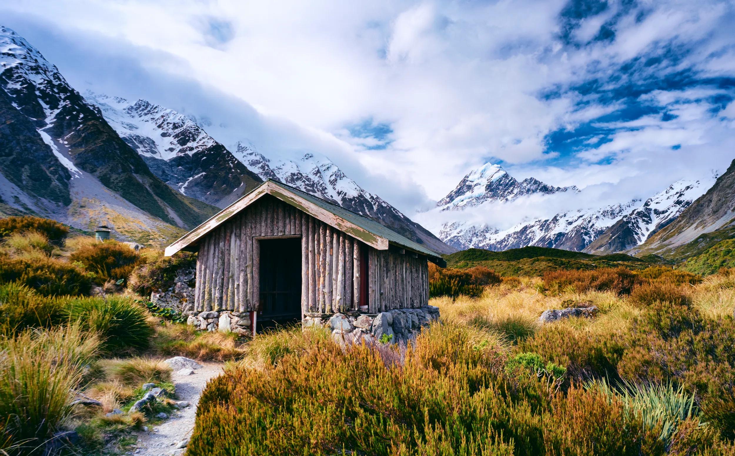 A walker's hut in the Hooker Valley. Looming in the distance are the magnificent Southern Alps and Mt Cook, New Zealand & Australasia's tallest mountain.