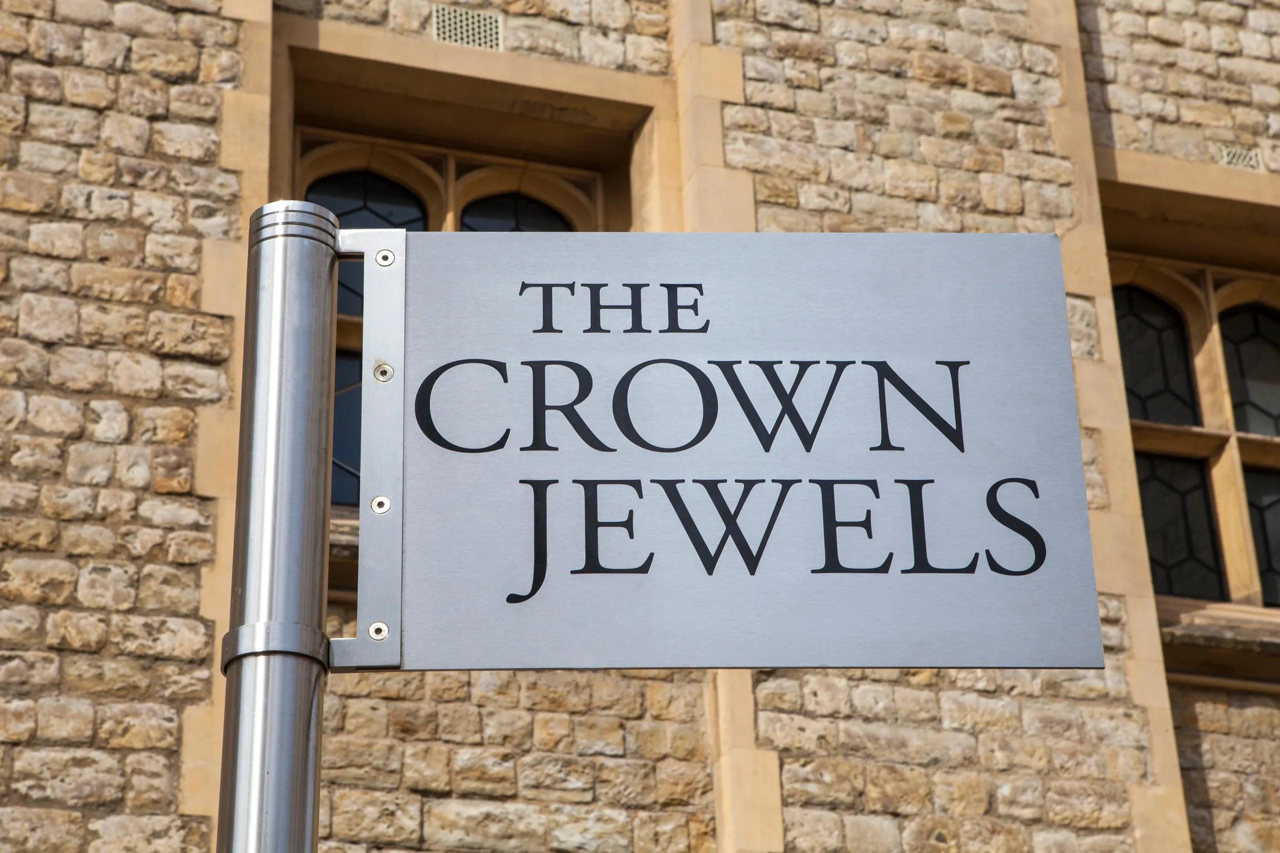 A sign pointing towards the location of the Royal Crown Jewels at the Tower of London.