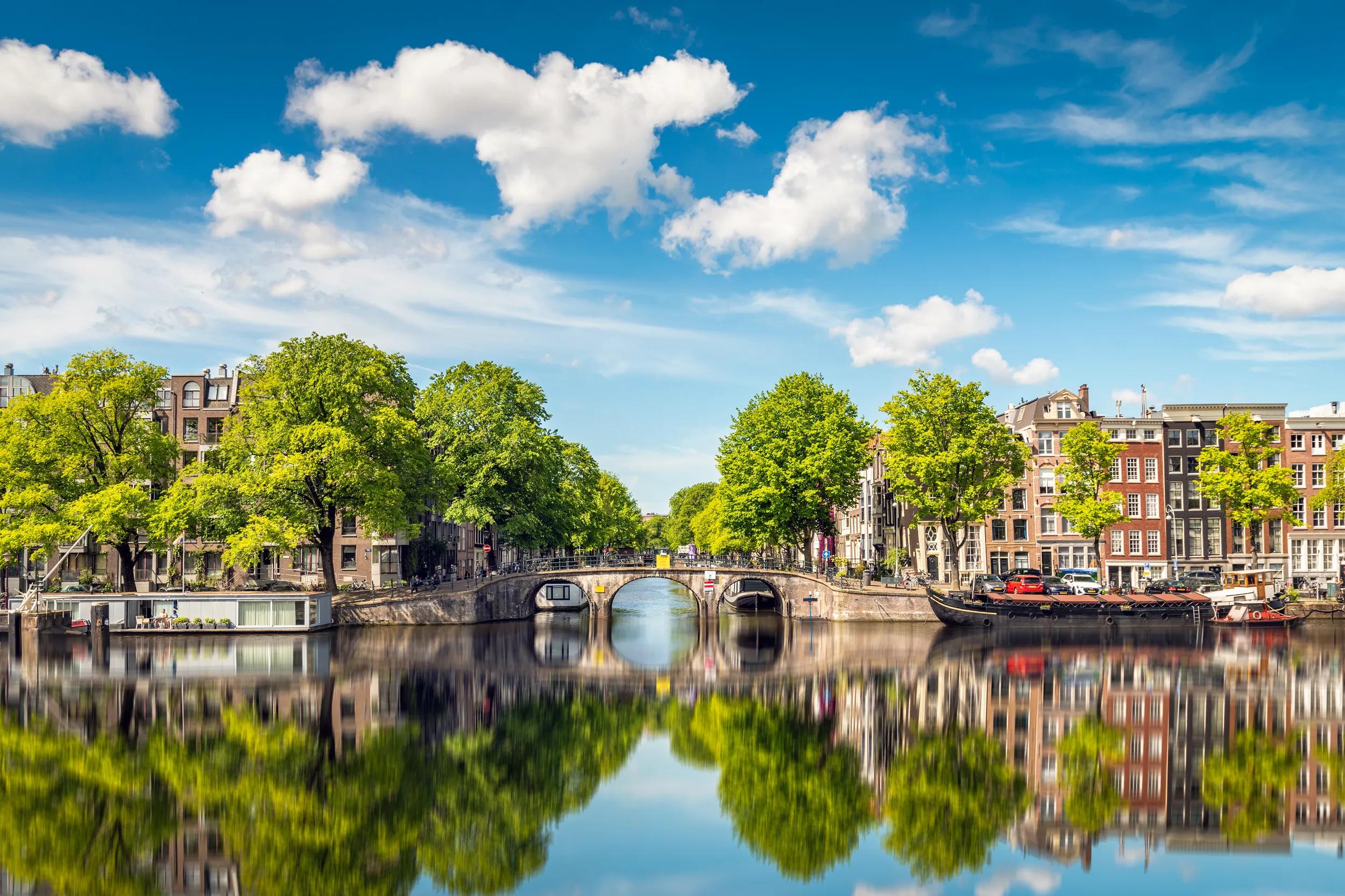 This is a photo of the beautiful old town of Amsterdam. It was shot on the Amstel river on a warm summer day with few clouds.