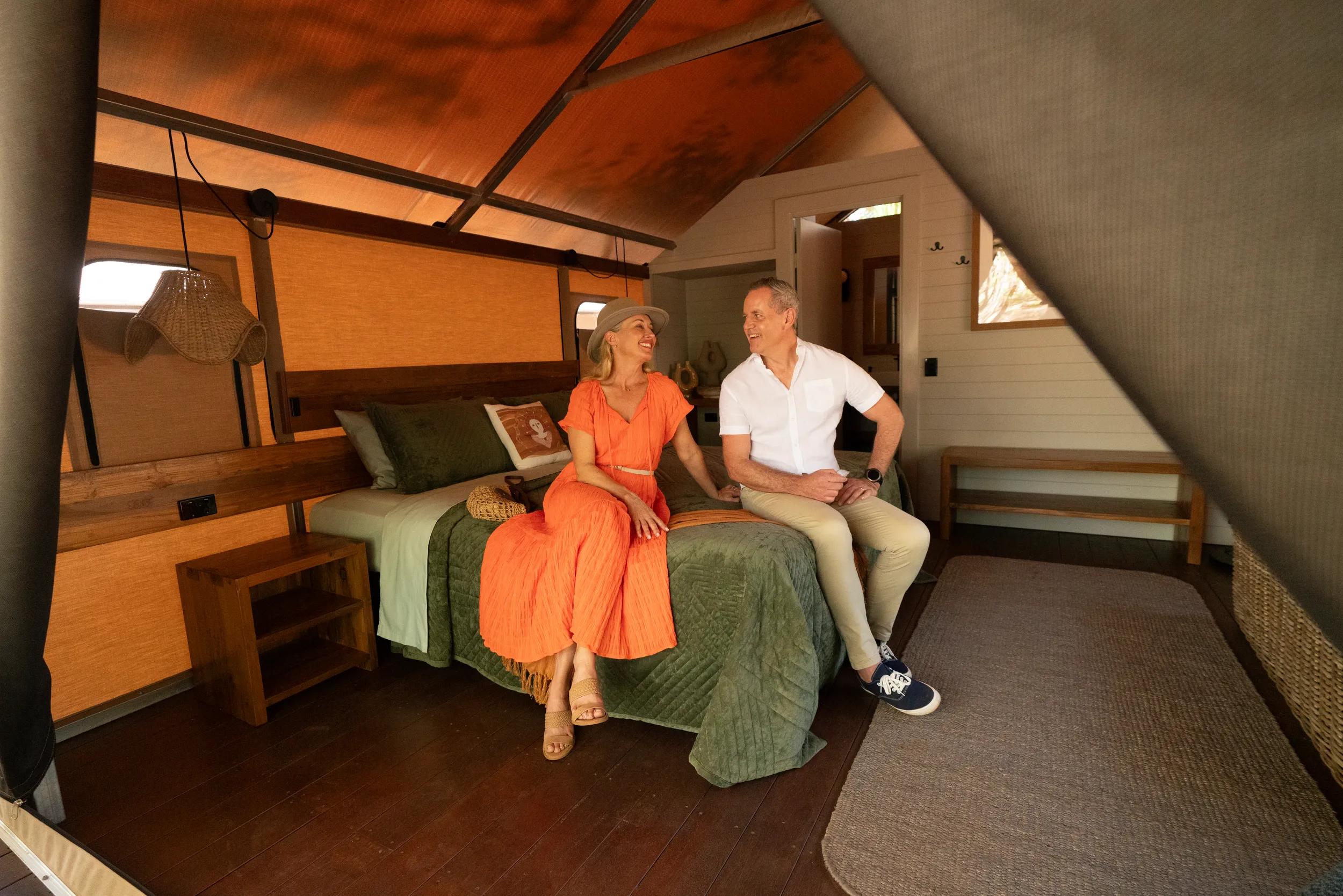 Lodge Accommodation - couple sitting on double bed - APT - Mitchell Falls photo shoot 2024.