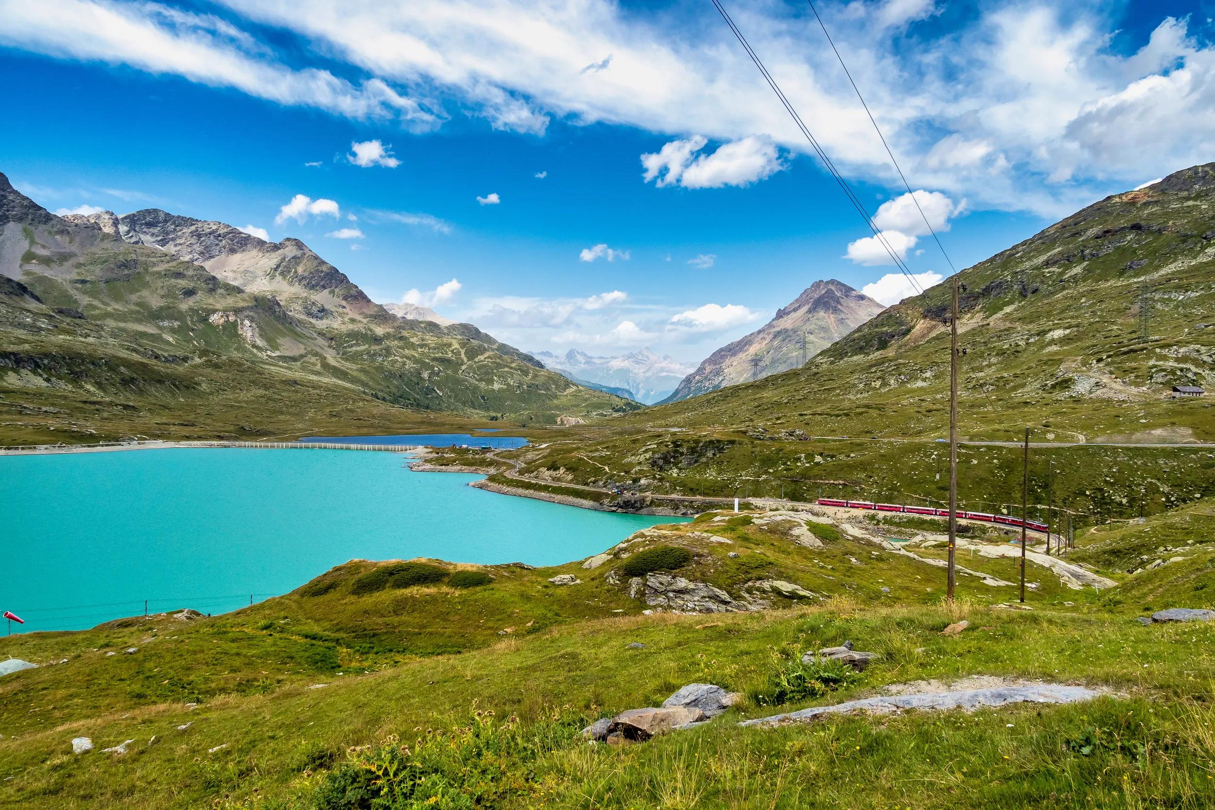 Bernina Express train at the White Lake in Ospizio Bernina, upper Engadin, Graubuenden, Grisons, Switzerland.