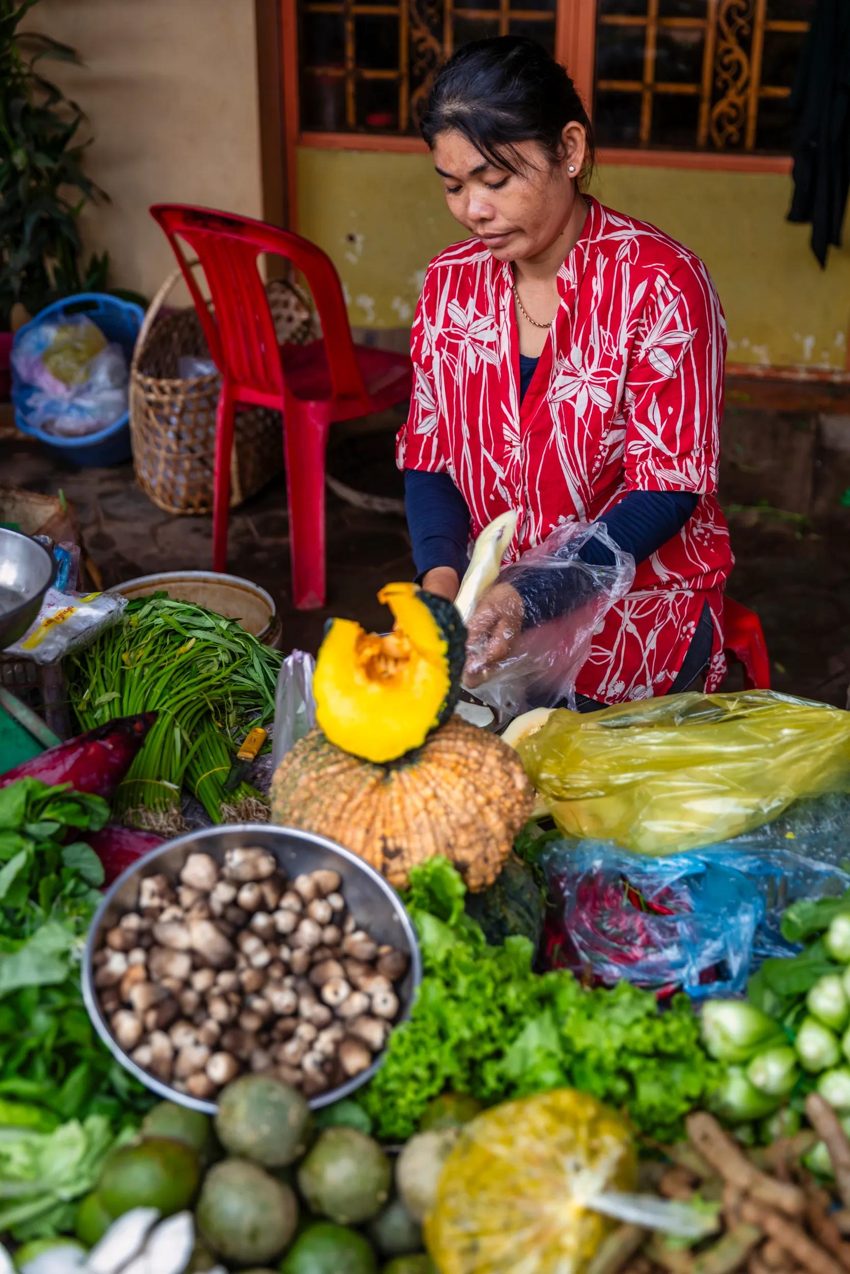 Cambodian woman selling fresh vegetables on a local market in Siem Reap, Cambodia