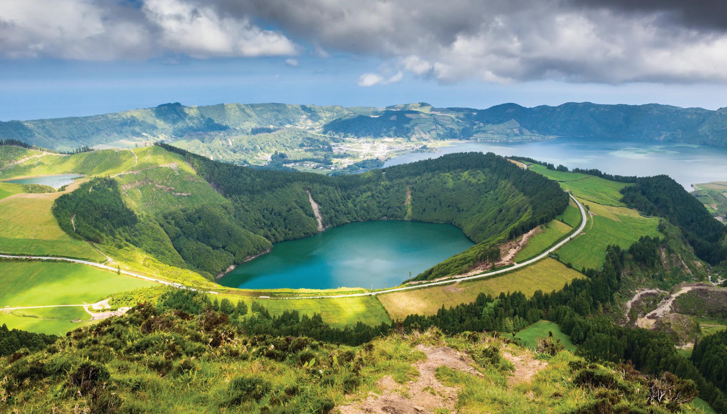 The Lagoa das Sete Cidades is one lake, referred as two separate bodies, the Green Lake and the Blue Lake (Lagoa Azul, background image), Lake Santiago front and Lake Rasa extreme left.