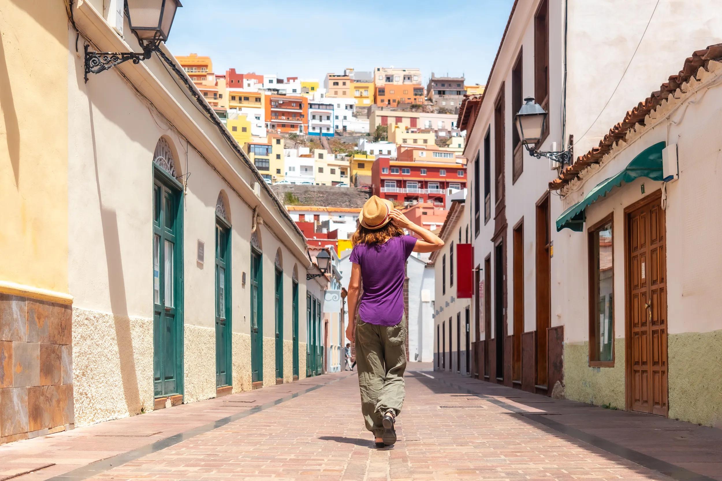 Woman on vacation walking through the city of San Sebastian de la Gomera next to the Iglesia De La Asuncion, Canary Islands