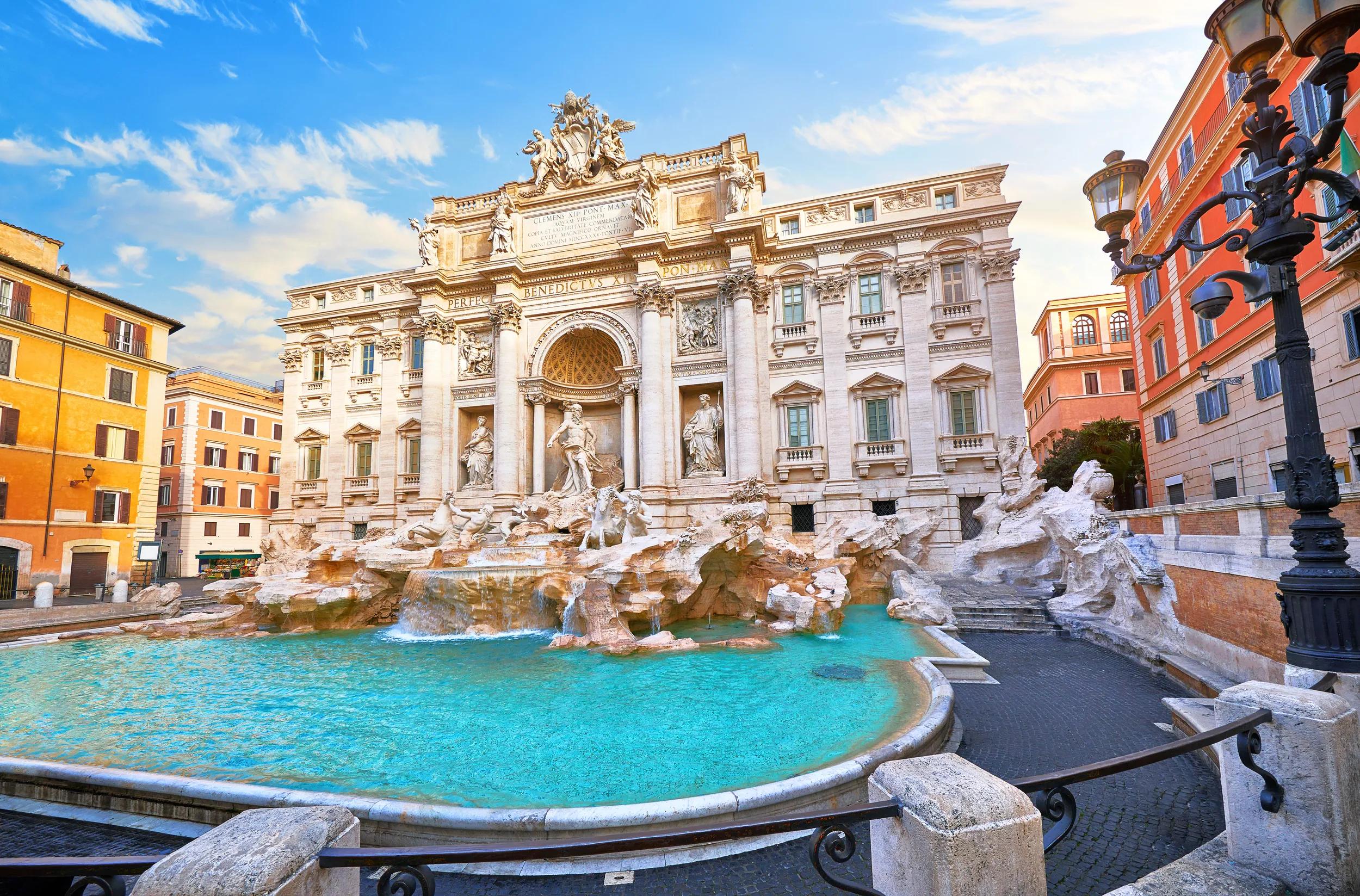 Trevi Fountain in Rome, Italy. Ancient fountain. Roman statues at piazza in old medieval city among traditional italian houses and street lamps. Famous landmark. Touristic destination for vacation.