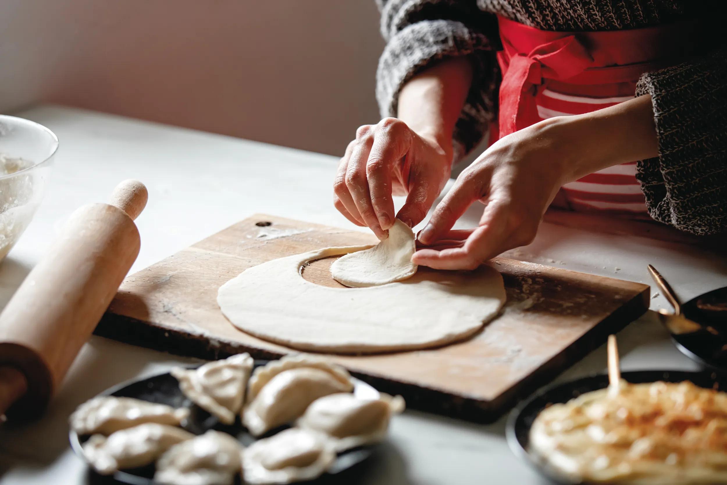 woman cooking  polish dumplings at kitchen