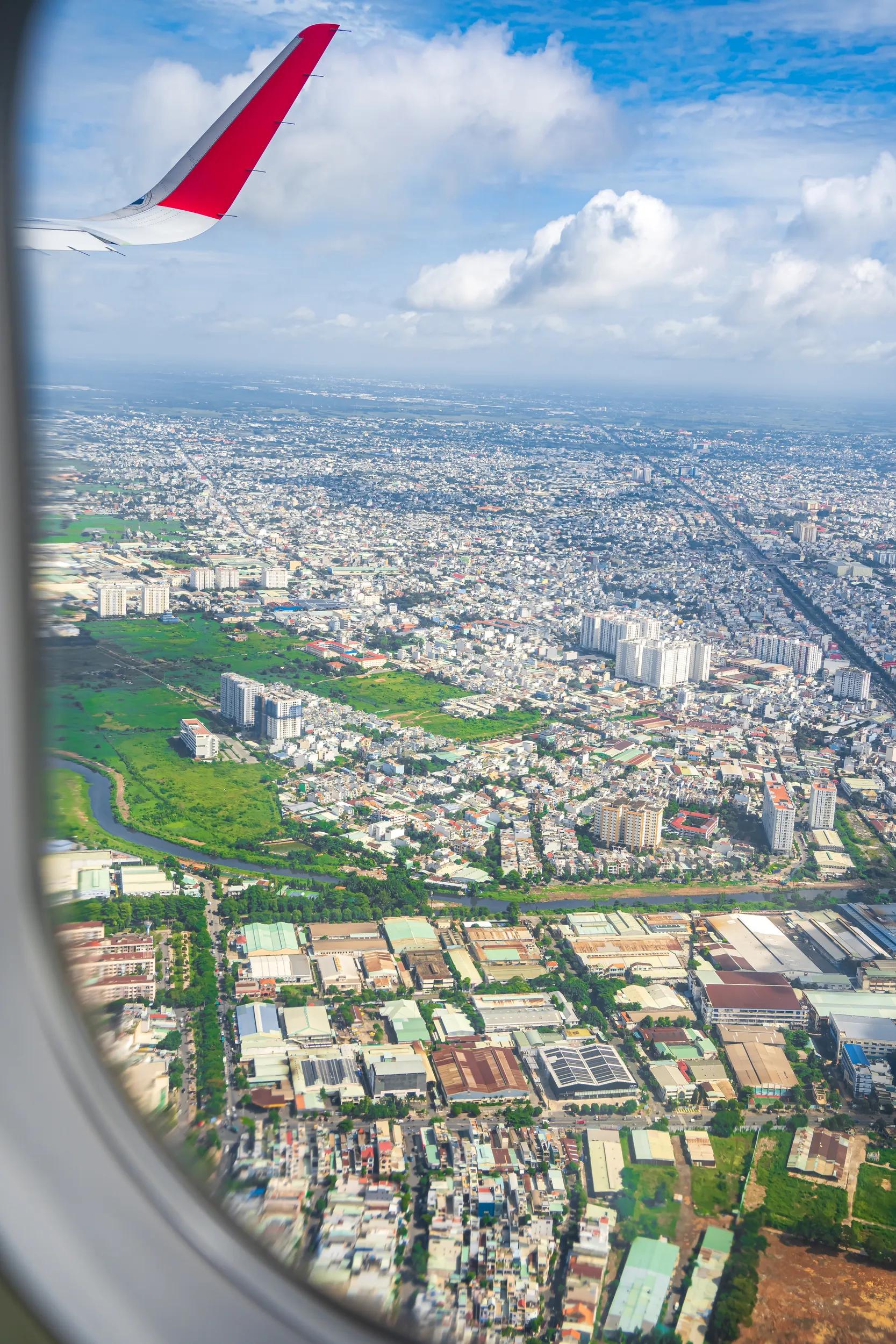 Looking from above the landscape of Ho Chi Minh City in Vietnam through the plane window when approaching the airport