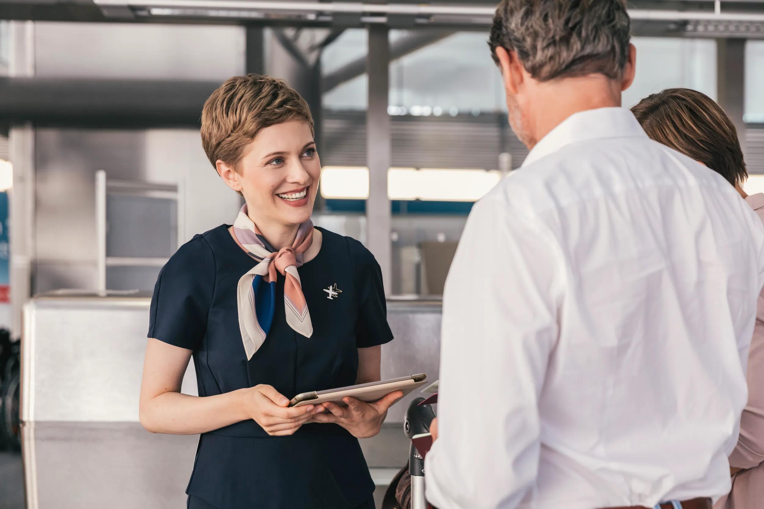 Smiling airline employee talking to couple at the airport