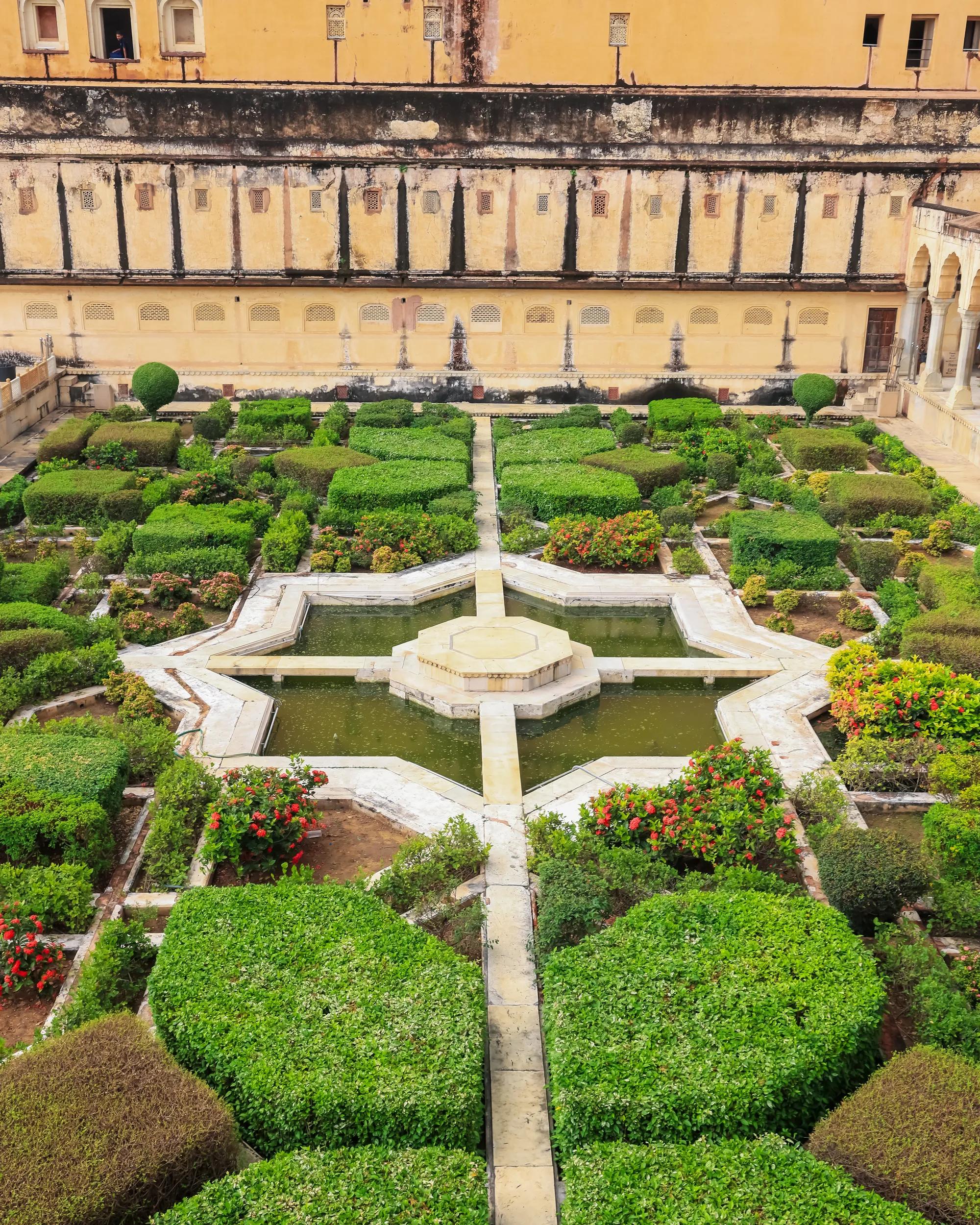 Amber Fort's Charbagh garden with geometric beds and water features in Jaipur, India.