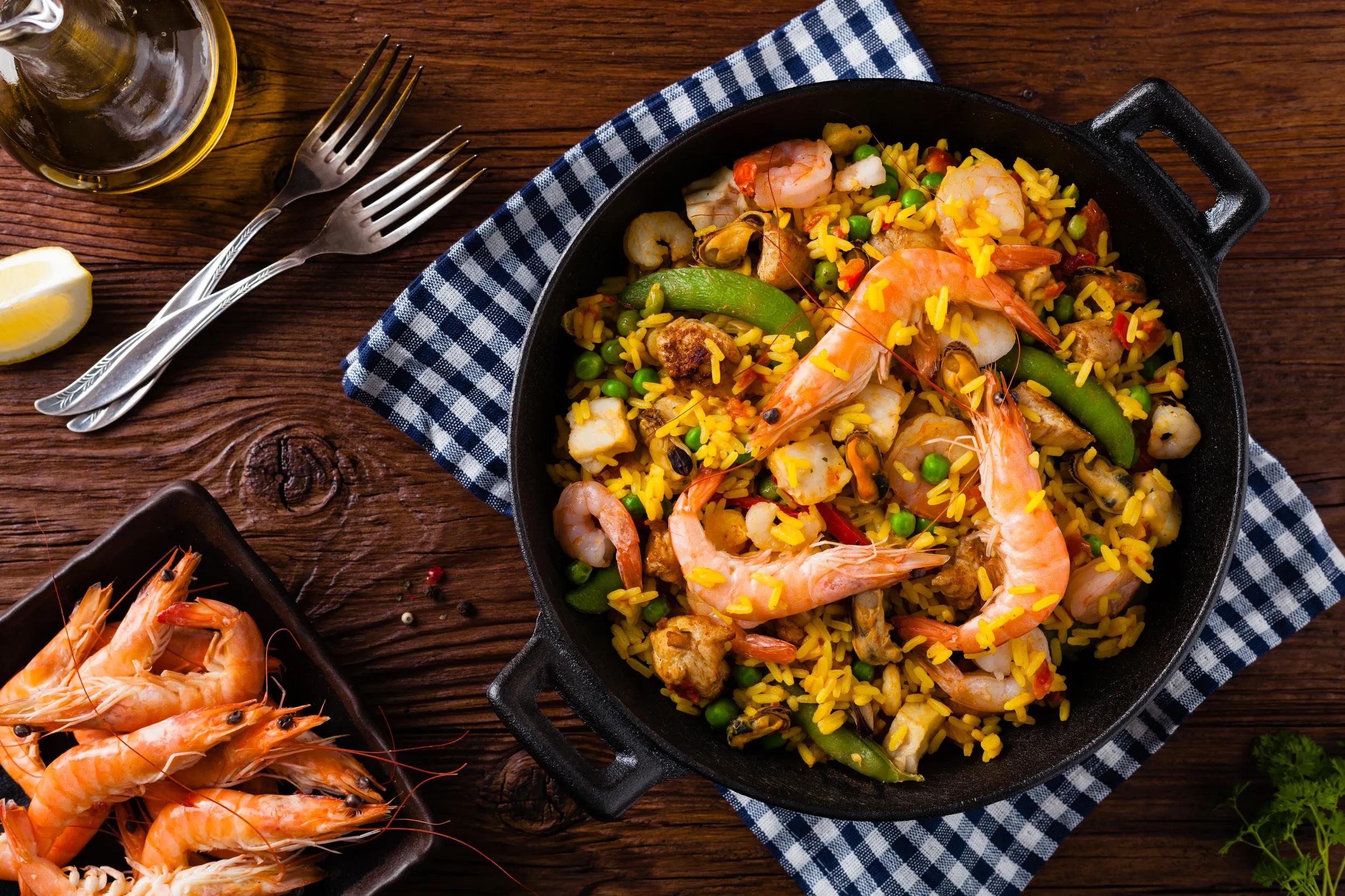 Traditional Spanish paella with seafood and chicken. Prepared in wook. Top view.