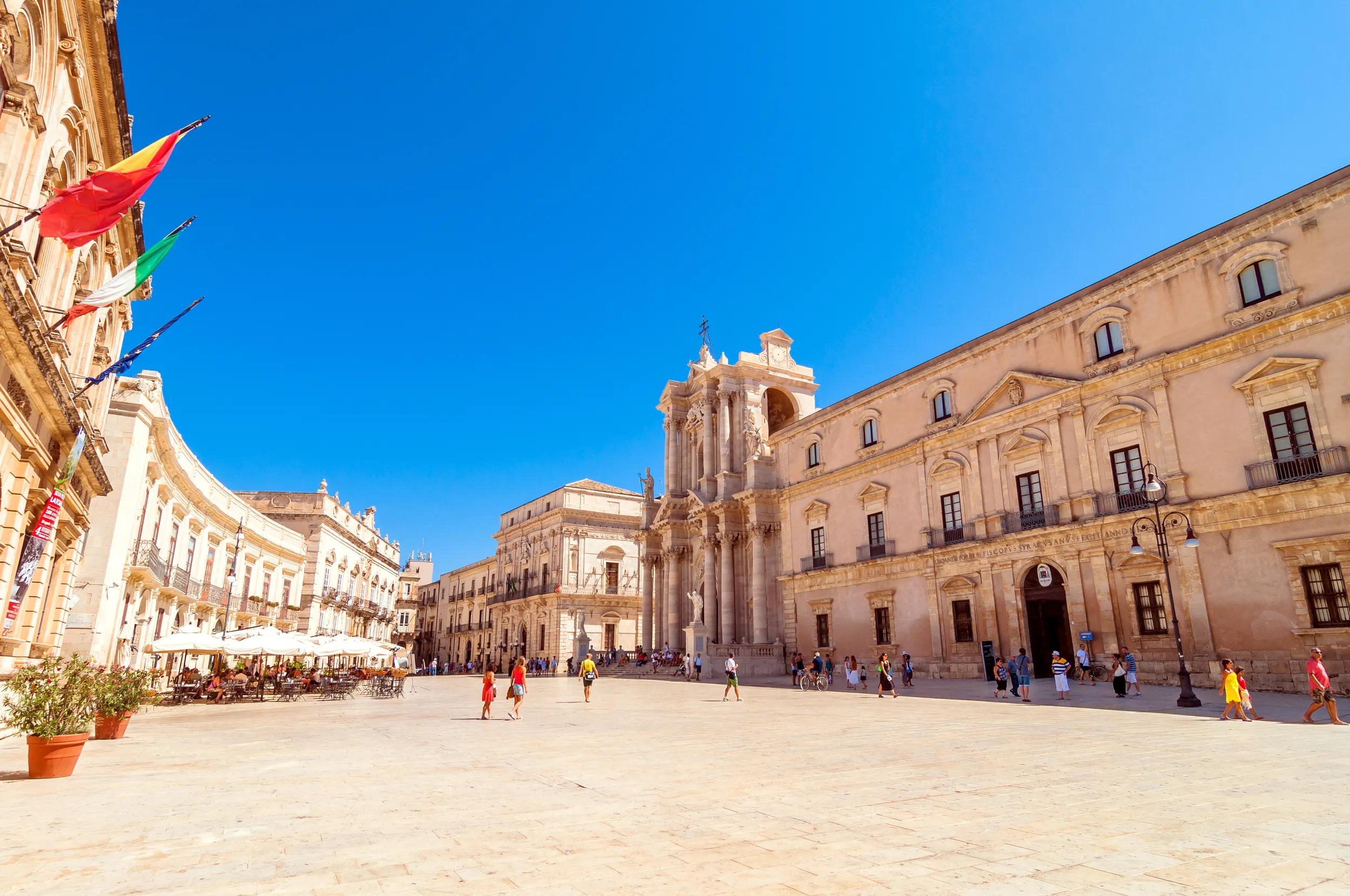 SYRACUSE, ITALY - AUGUST 16, 2014: tourists and locals visit main square Piazza del Duomo in Ortigia, Syracuse, Italy. Ortigia is a small island which is the historical centre of the city of Syracuse, Sicily.