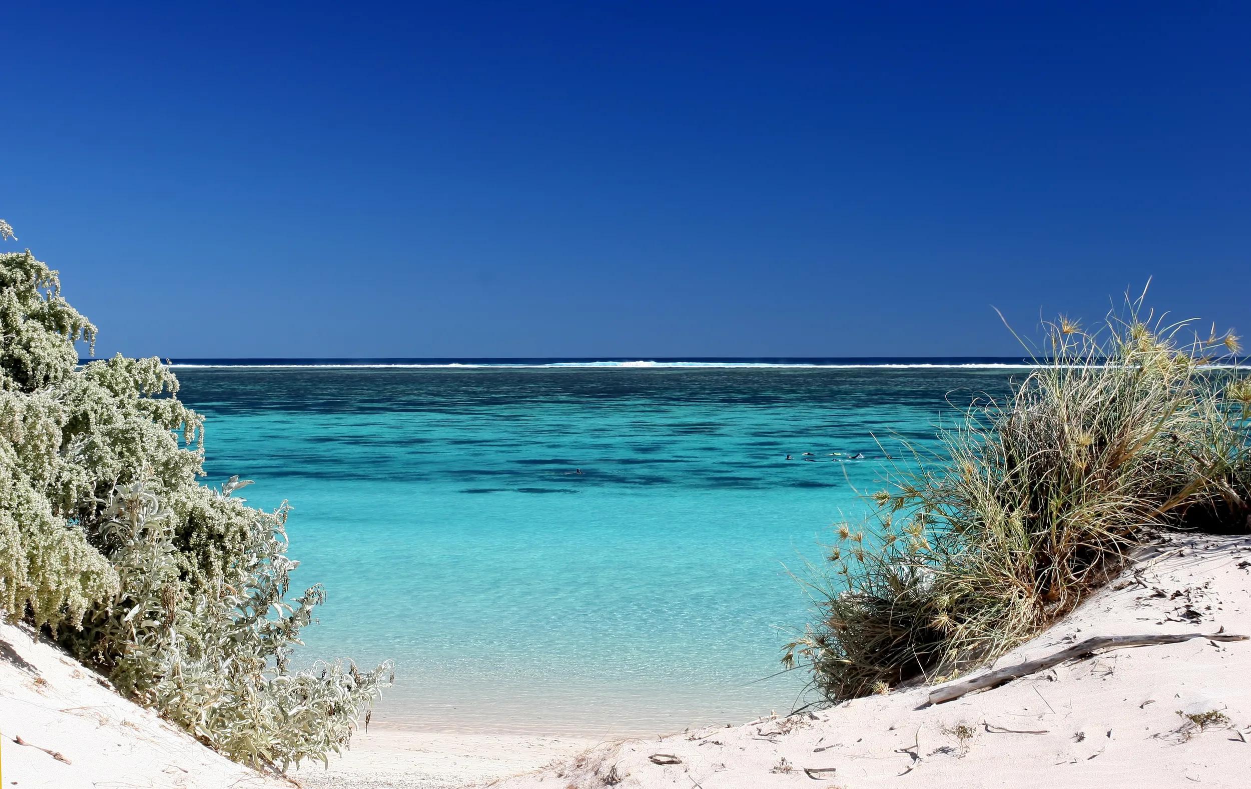 View of the pristine turquois waters through gap in the dunes at Ningaloo reef Western Australia
