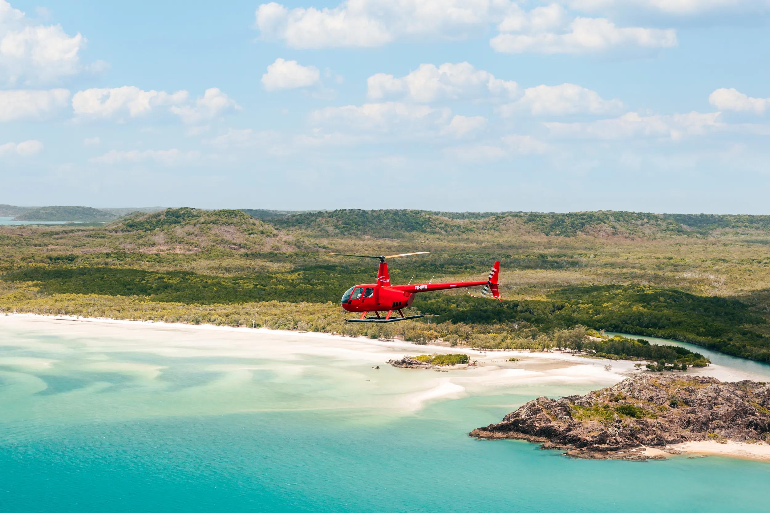 Helicopter flying over the beach and bay on the western side of the tip of Australia.