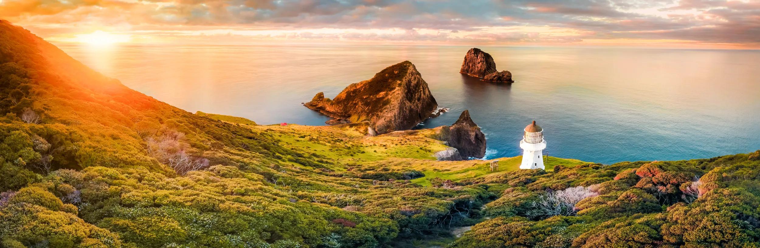 Scenic panorama of Cape Brett lighthouse on the coast of New Zealand during sunset. Located in Bay of Islands, popular tourist destination for its natural beauty.