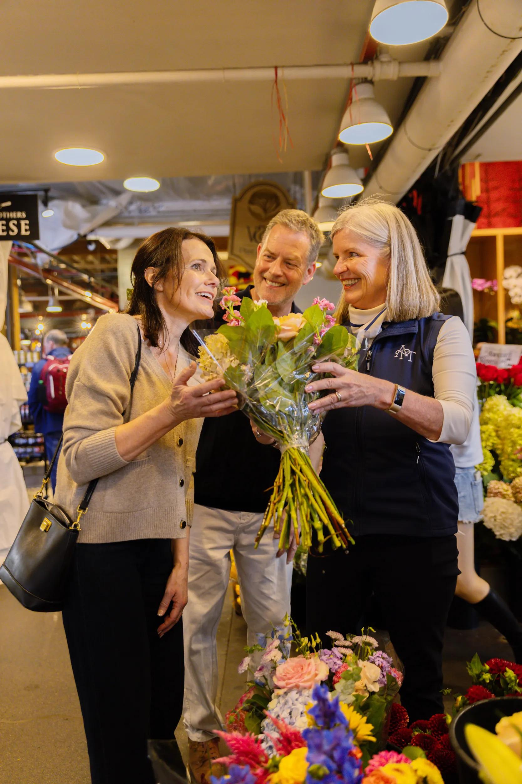 Guest couple with APT Tour Director at Public Market, interior, Granville Island, Vancouver, Canada.