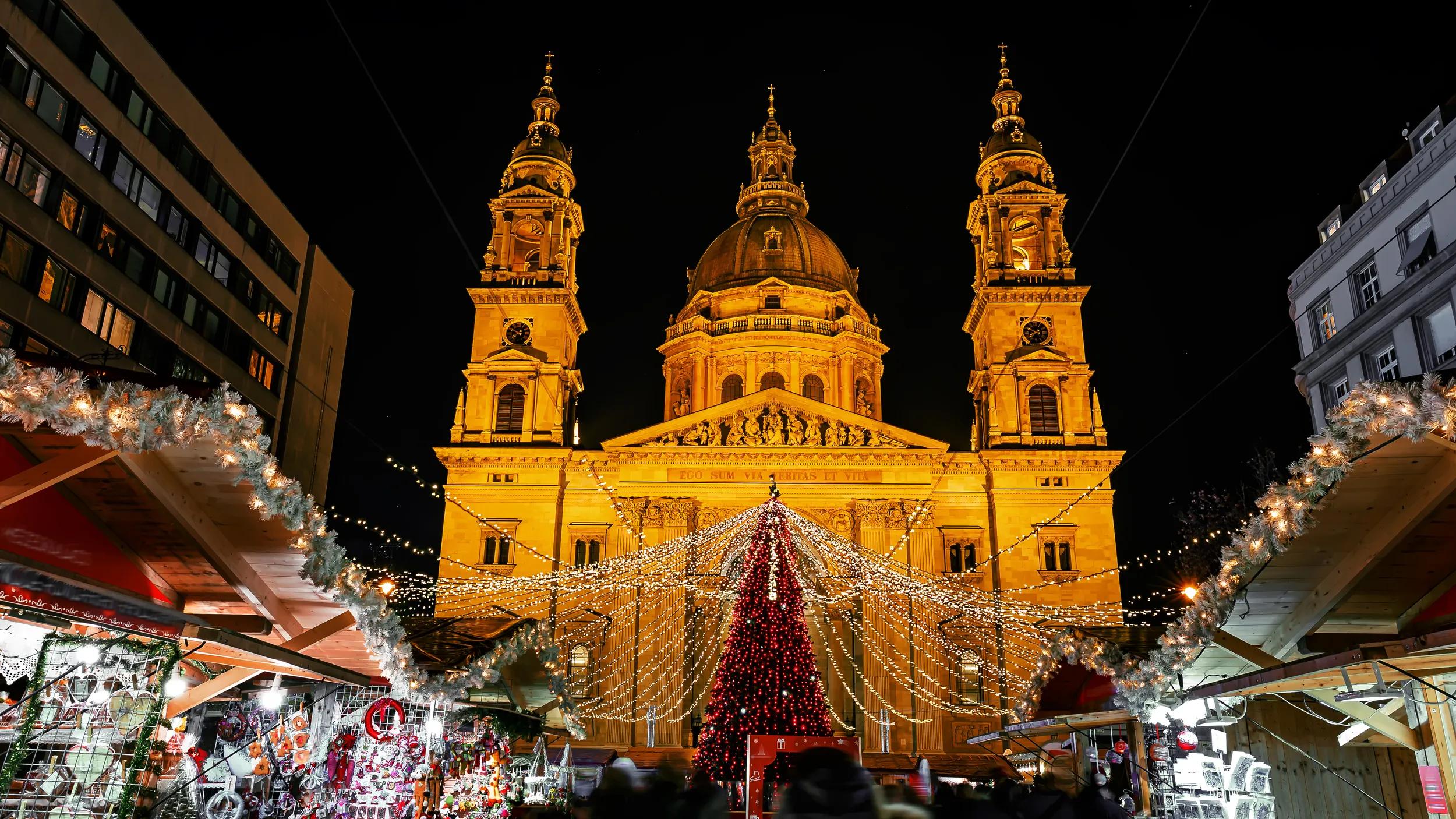 Christmas market on Vorosmarty square before Saint Stephen basilica in the evening lights - Budapest, Hungary