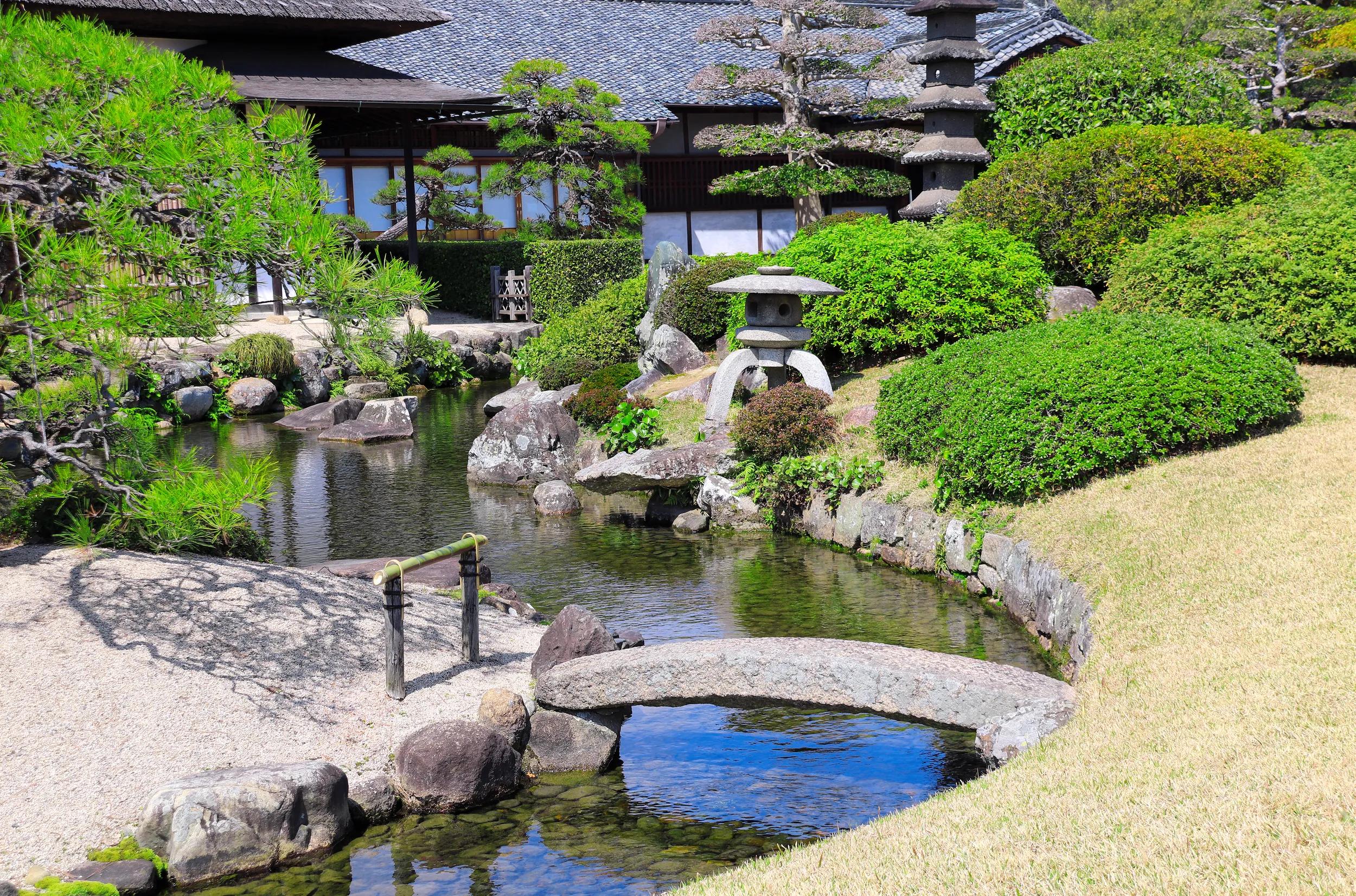 Decorative pond, bridge and stone island with pine in Koishikawa Korakuen garden, Okayama, Japan