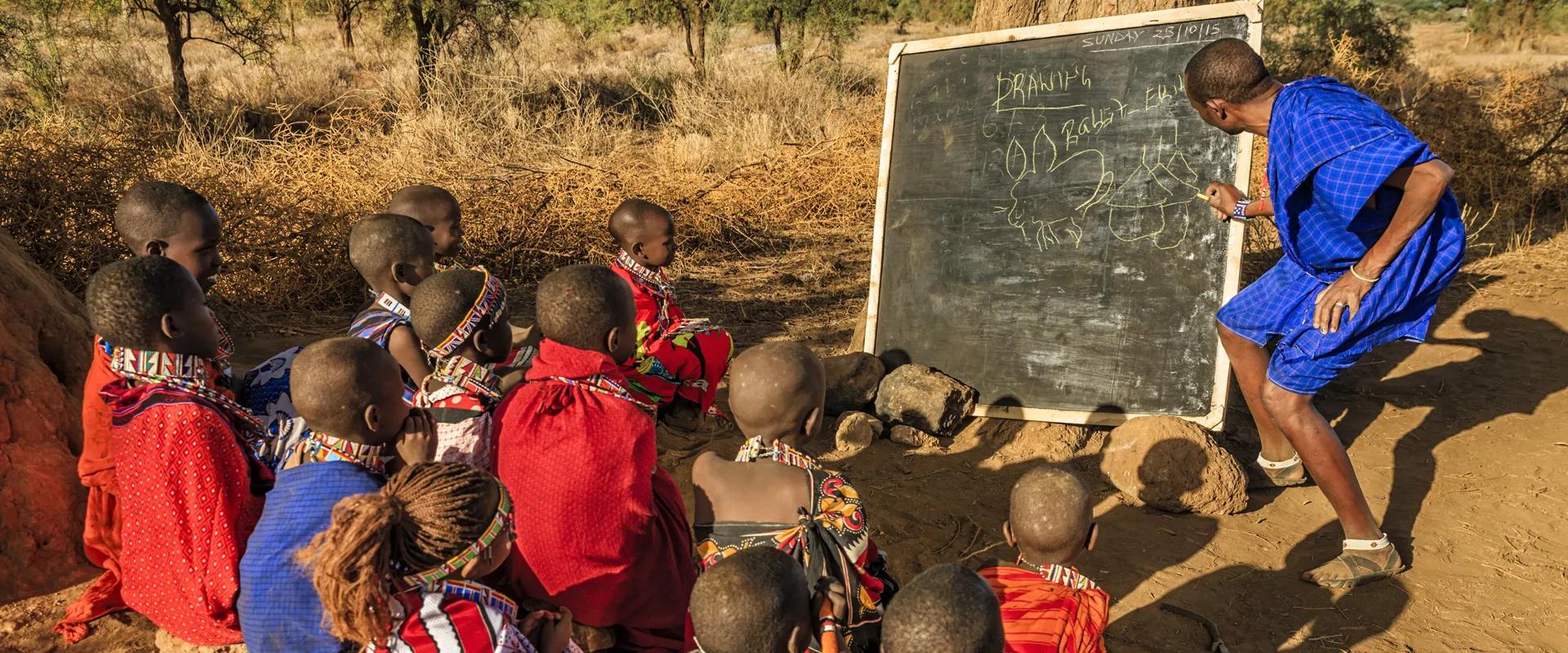 African children  from Maasai tribe during classes under the acacia tree in remote village, Kenya, East Africa. Maasai tribe inhabiting southern Kenya and northern Tanzania, and they are related to the Samburu.