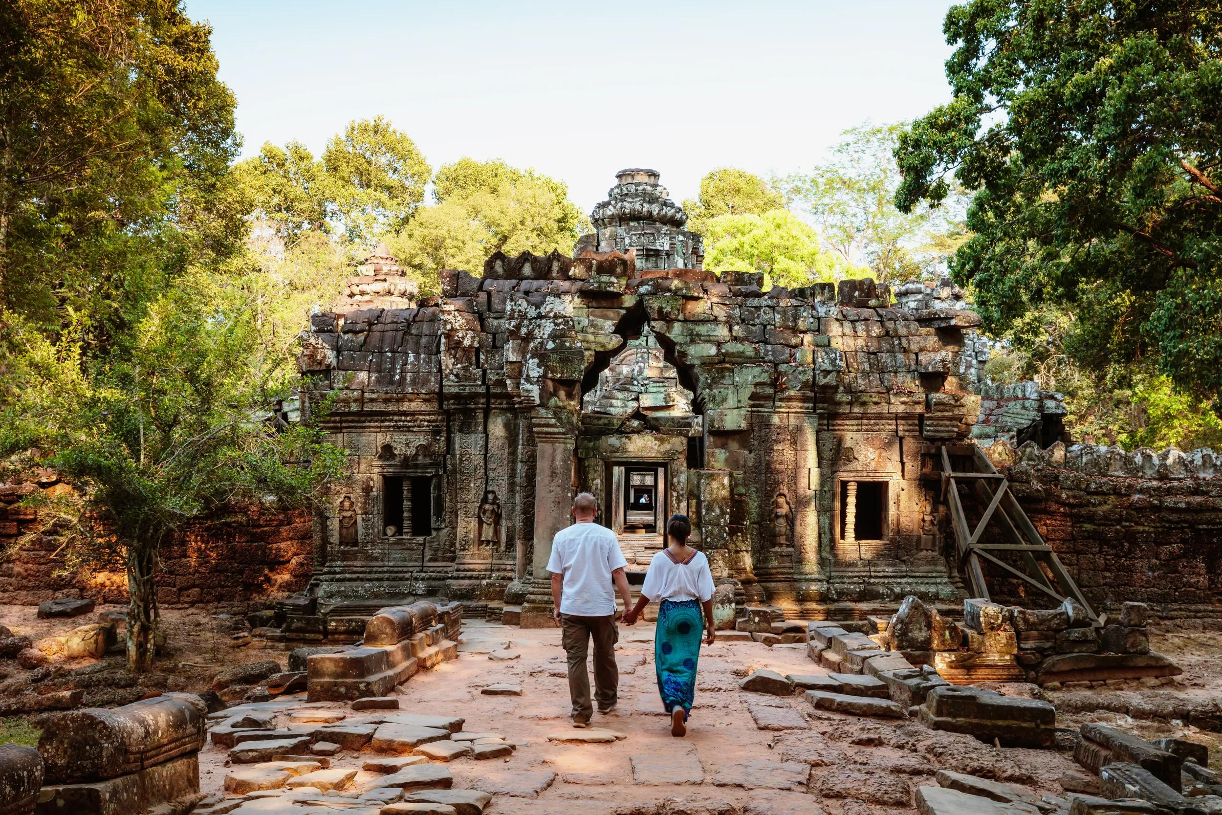 Adult couple of tourists visiting the temple ruins of Angkor, Siem Reap, Cambodia