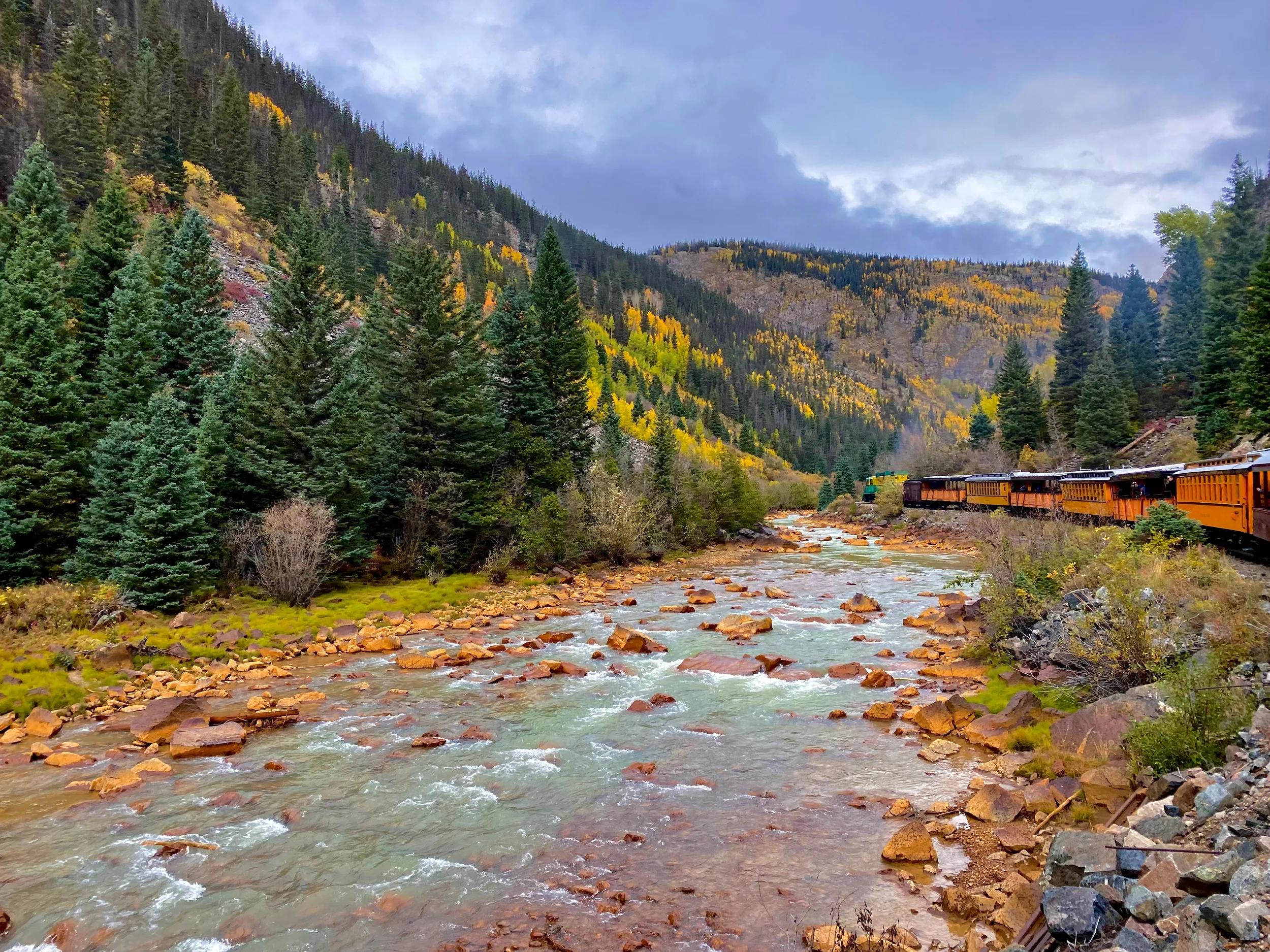 Shallow river with narrow gauge train in Colorado mountains