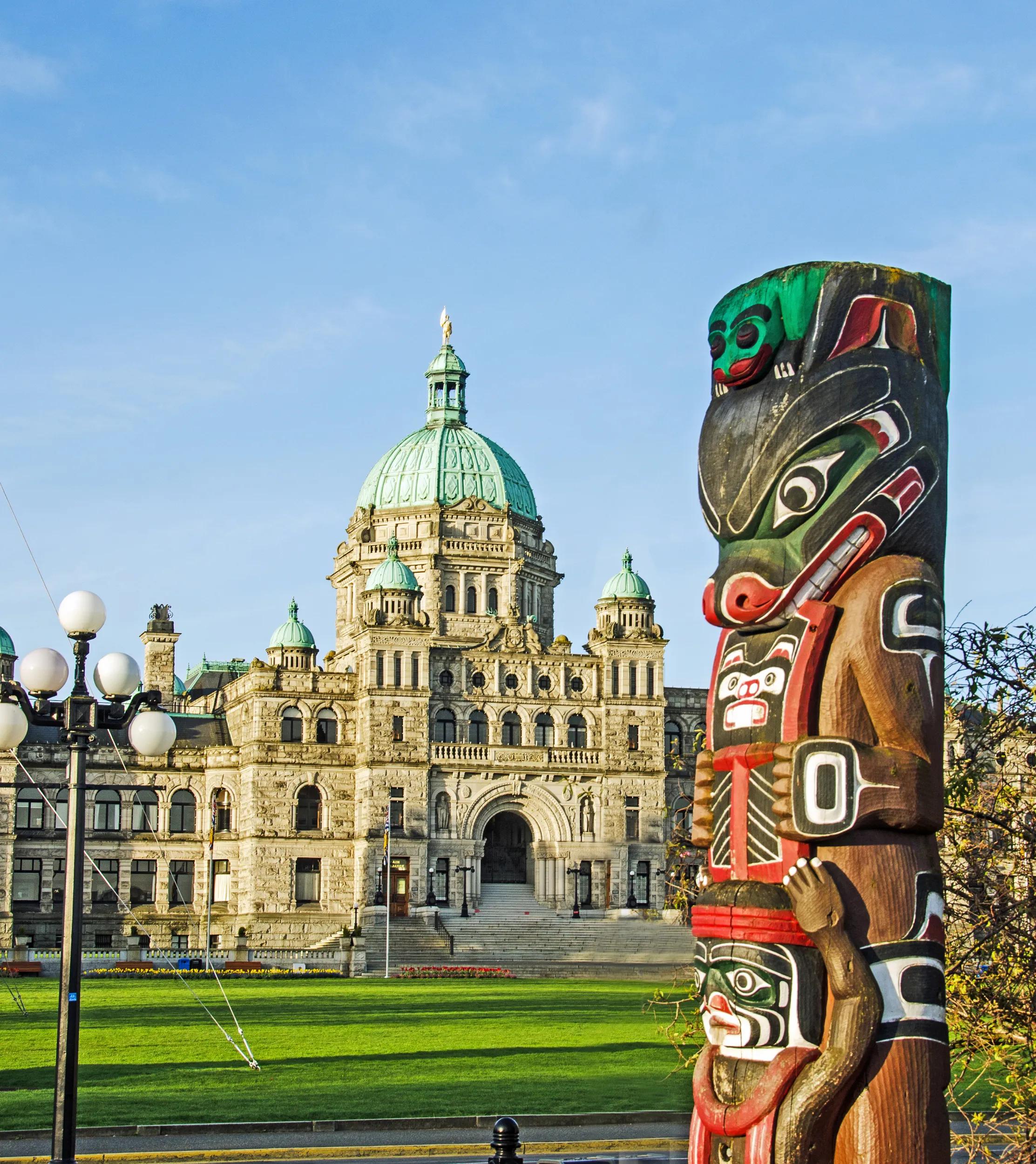 Parliament Building in Victoria, British Columbia, A hand made aboriginal totem pole depicting bears is across the street from the grounds.