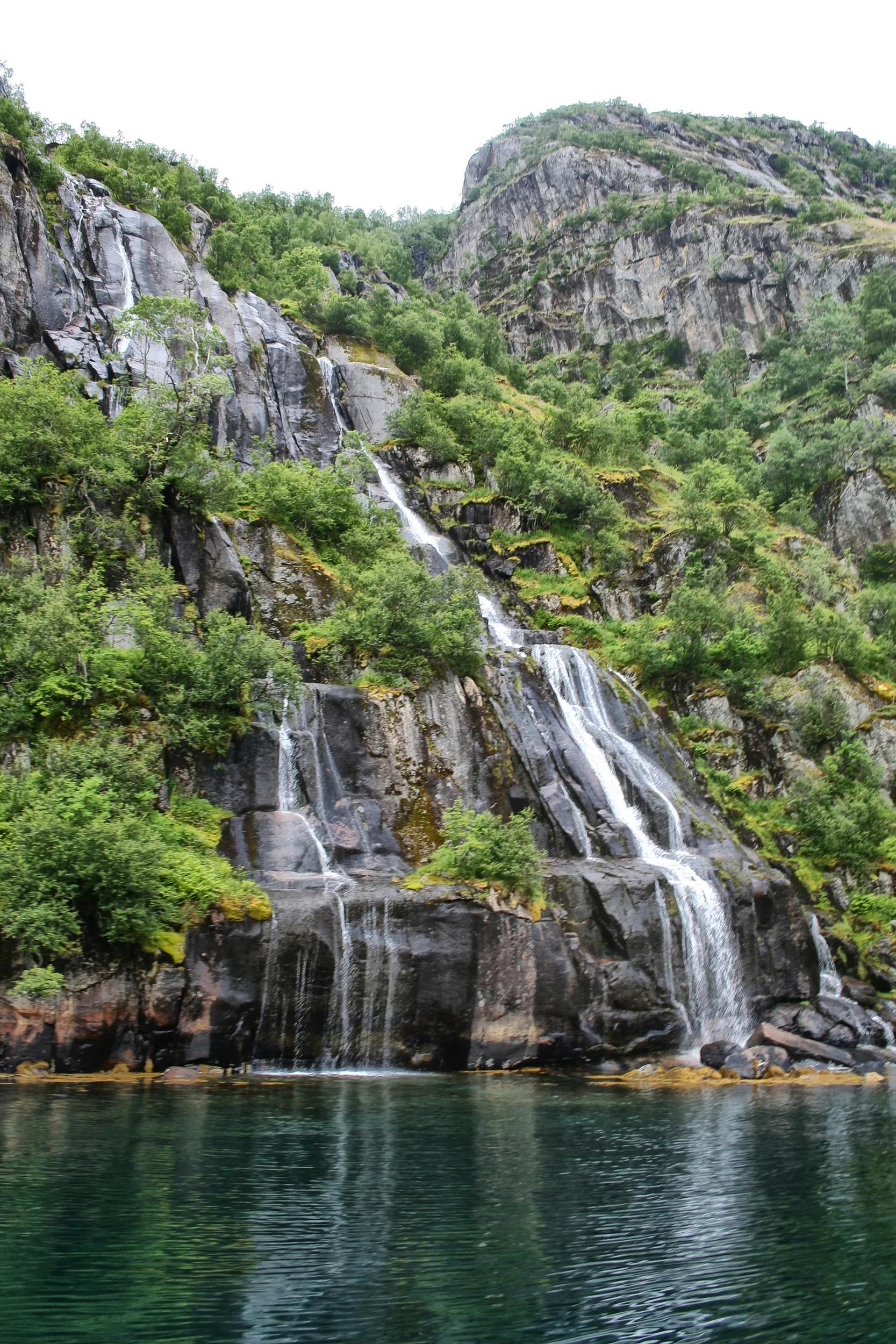 Lovely waterfall cascading into tourist attraction of Troll fjord.