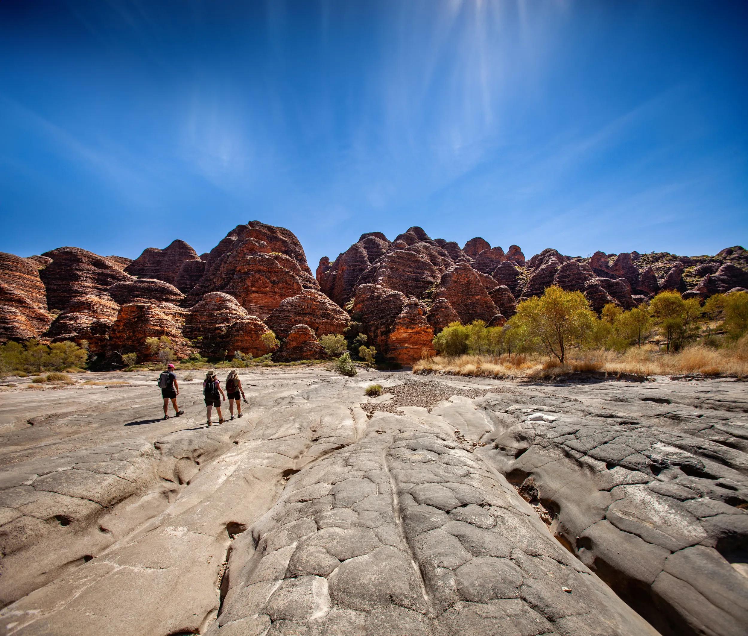 Three figures trekking in the Bungle, Bungle Range, Kimberley, Western Australia.