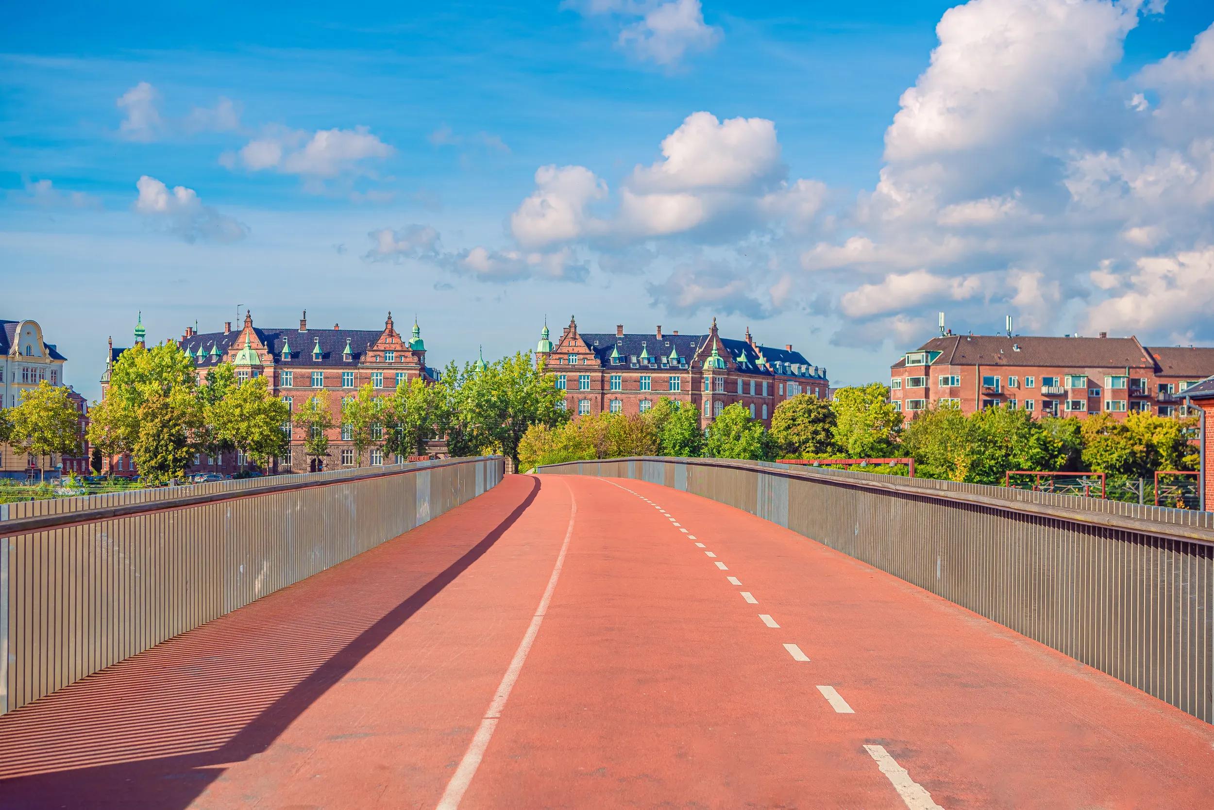 Pedestrian and bicycle bridge across the railways takes towards residential buildings. Copenhagen, Denmark