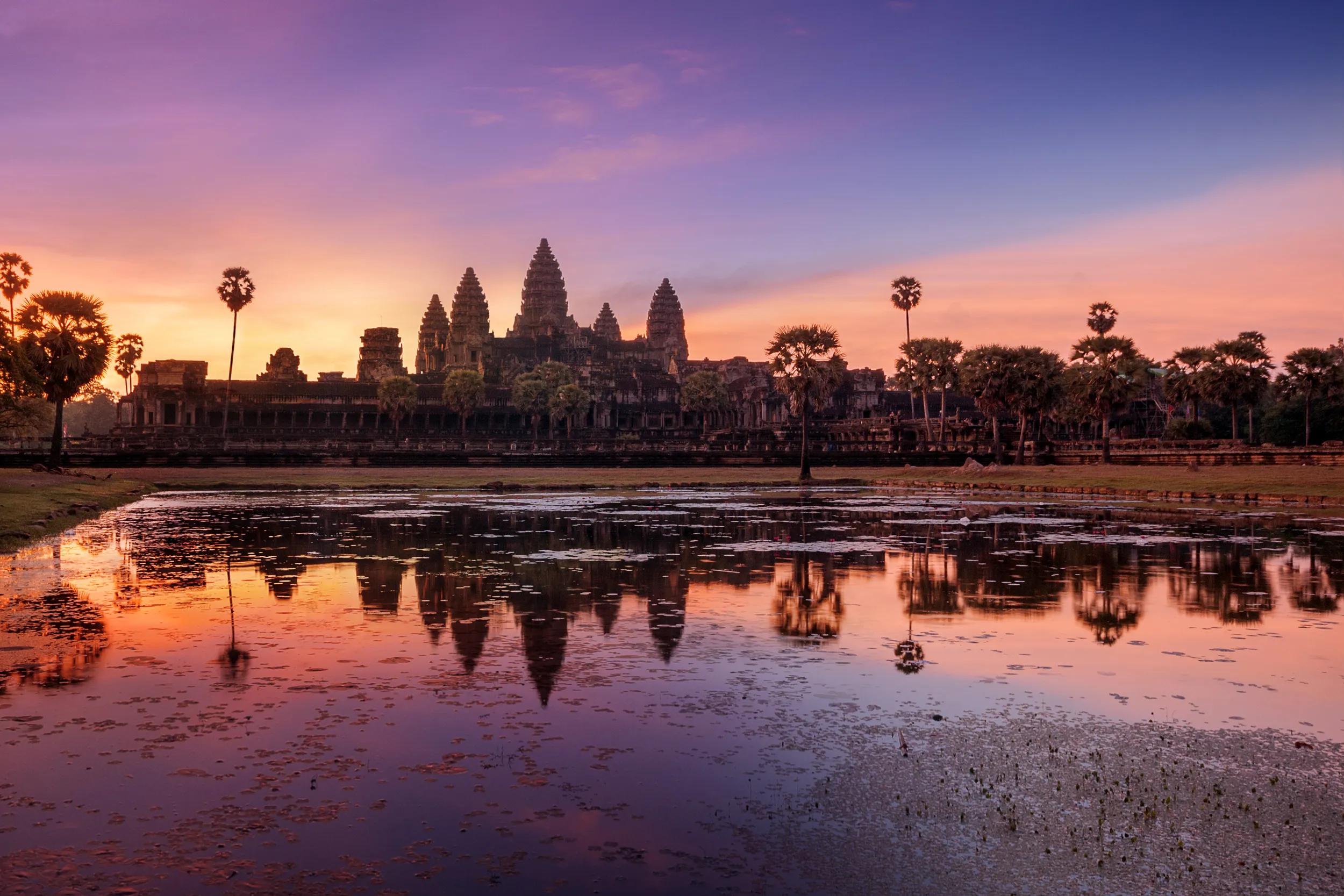 Sunrise with Angkor Wat, Siem Reap, Cambodia.Angkor Wat is a temple complex in Cambodia and the largest religious monument in the world, with the site measuring 162.6 hectares (1,626,000 m2; 402 acres). It was originally constructed as a Hindu temple of god Vishnu for the Khmer Empire, gradually transforming into a Buddhist temple toward the end of the 12th century. As the best-preserved temple at the site, it is the only one to have remained a significant religious center since its foundation. The temple is at the top of the high classical style of Khmer architecture. It has become a symbol of Cambodia, appearing on its national flag, and it is the country's prime attraction for visitors.