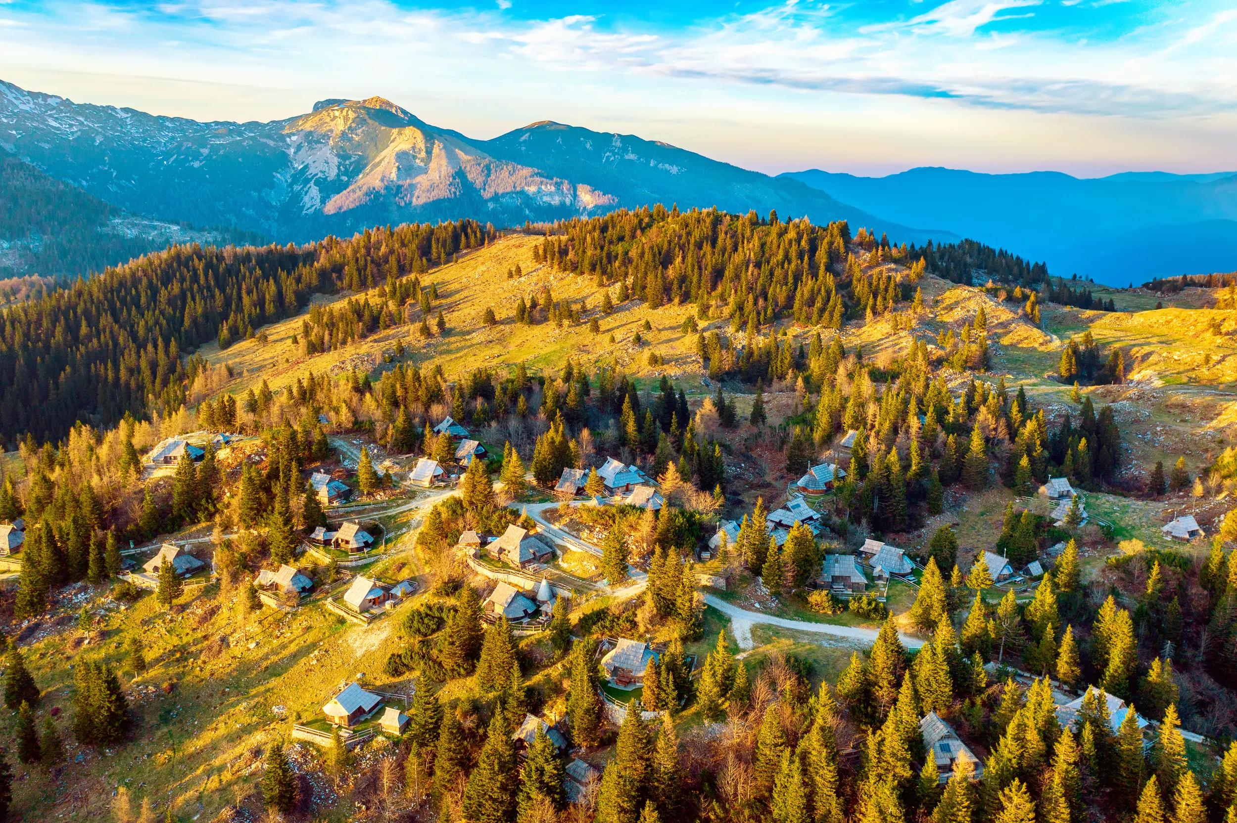 Mountain village in Alps, wooden houses in traditional style, Velika Planina, Kamnik, Slovenia. Summer touristic destination background. View from above