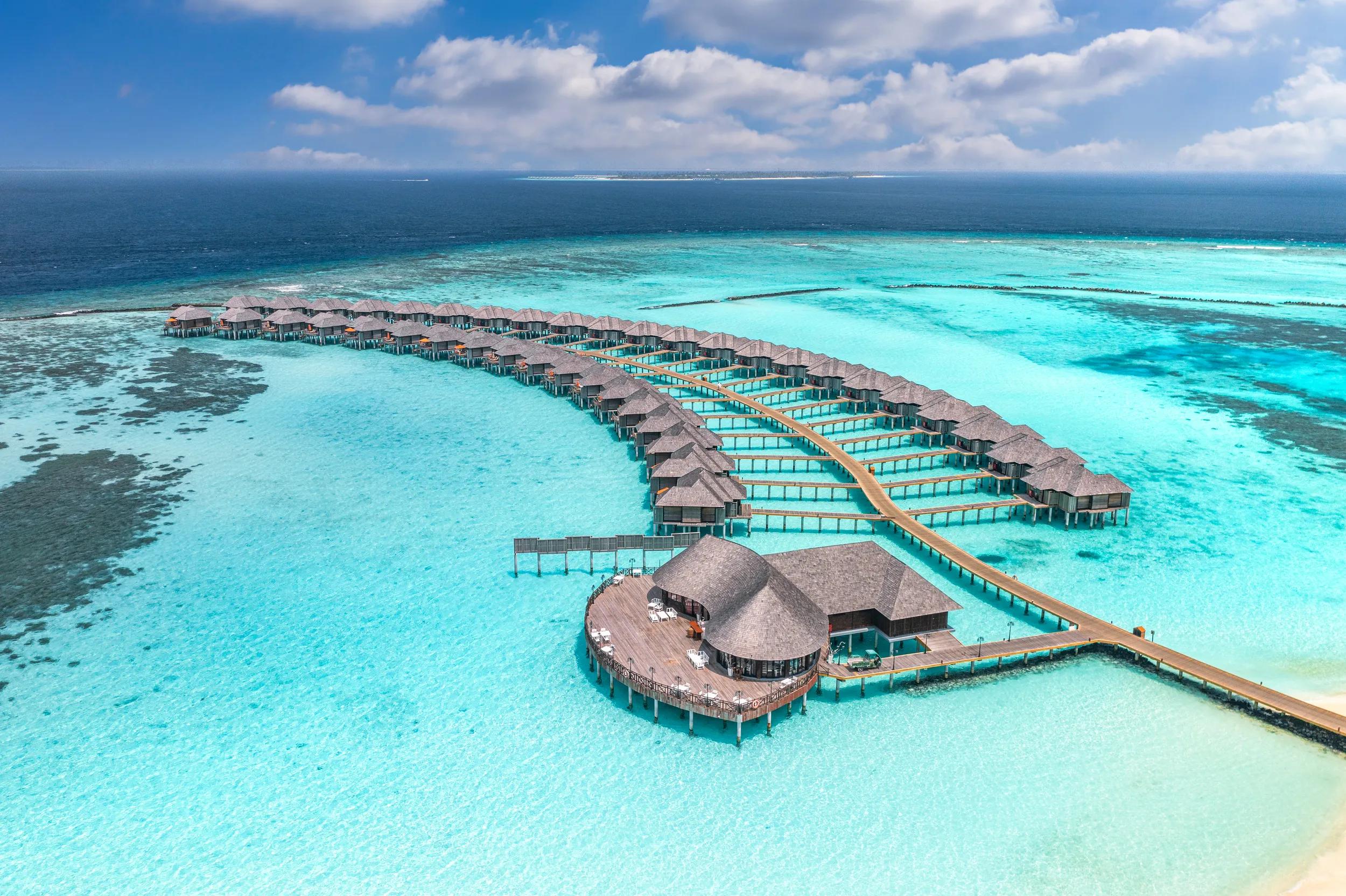 Maldives paradise island. Tropical aerial landscape, seascape with pier, water bungalows villas with amazing sea lagoon beach. Exotic tourism destination, summer vacation background. Aerial travel