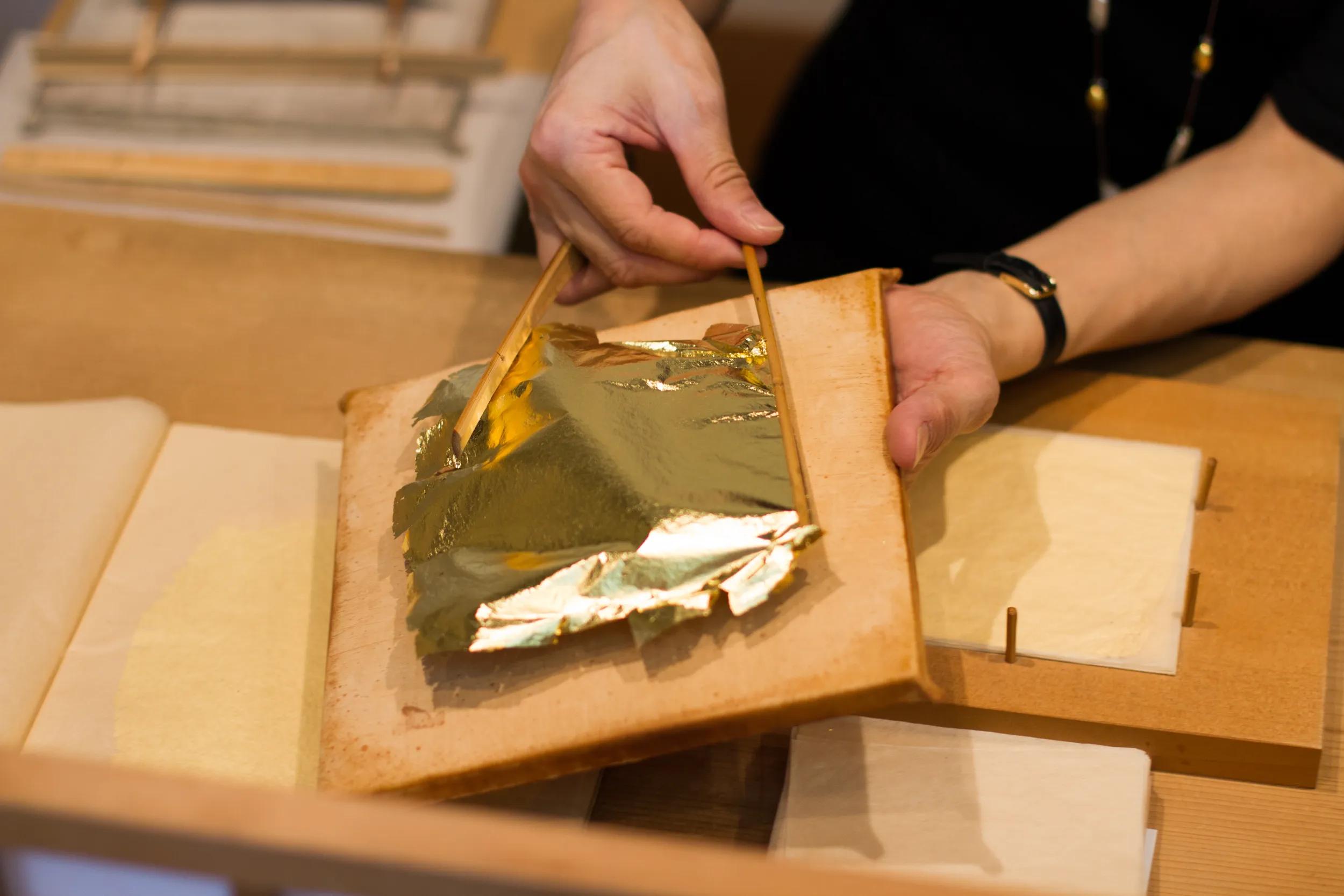 A craftsman demonstrating Kanazawa Wagasa, a traditional Japanese method of gold leaf.