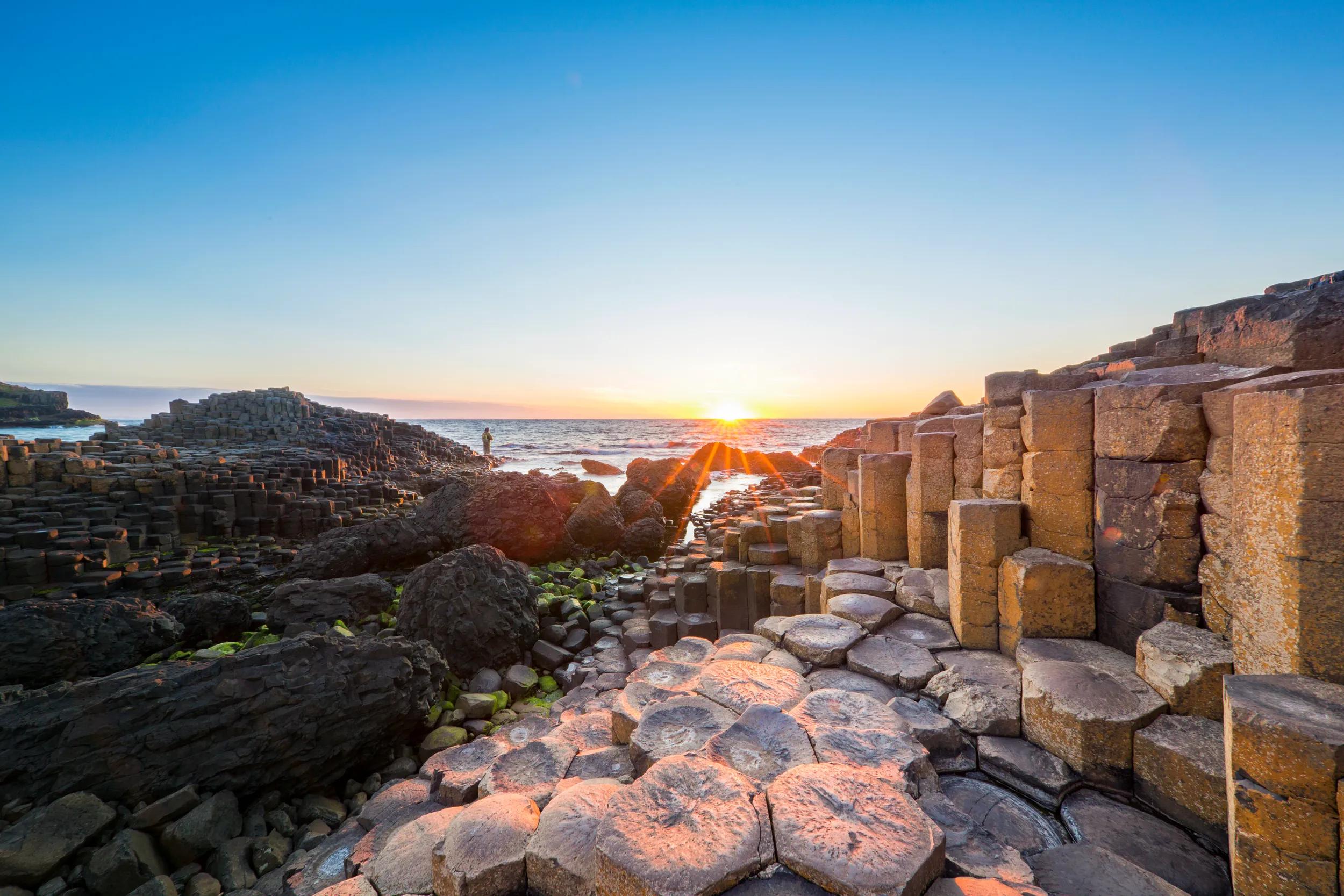Tourist on basalt column at Giants Causeway