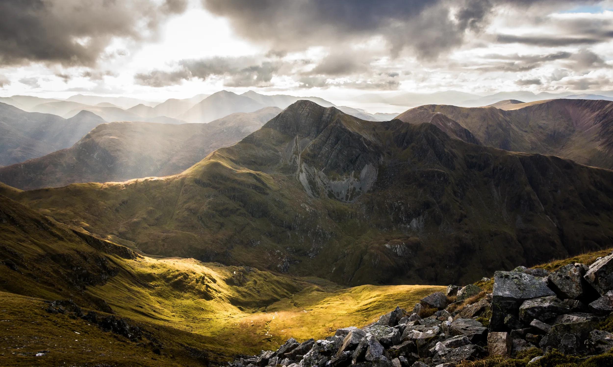 Stob Ban in Glen Nevis taken from Sgurr a'Mhaim with mid Autumn sun illuminating the glen below with layers of Glencoe mountains in the background.